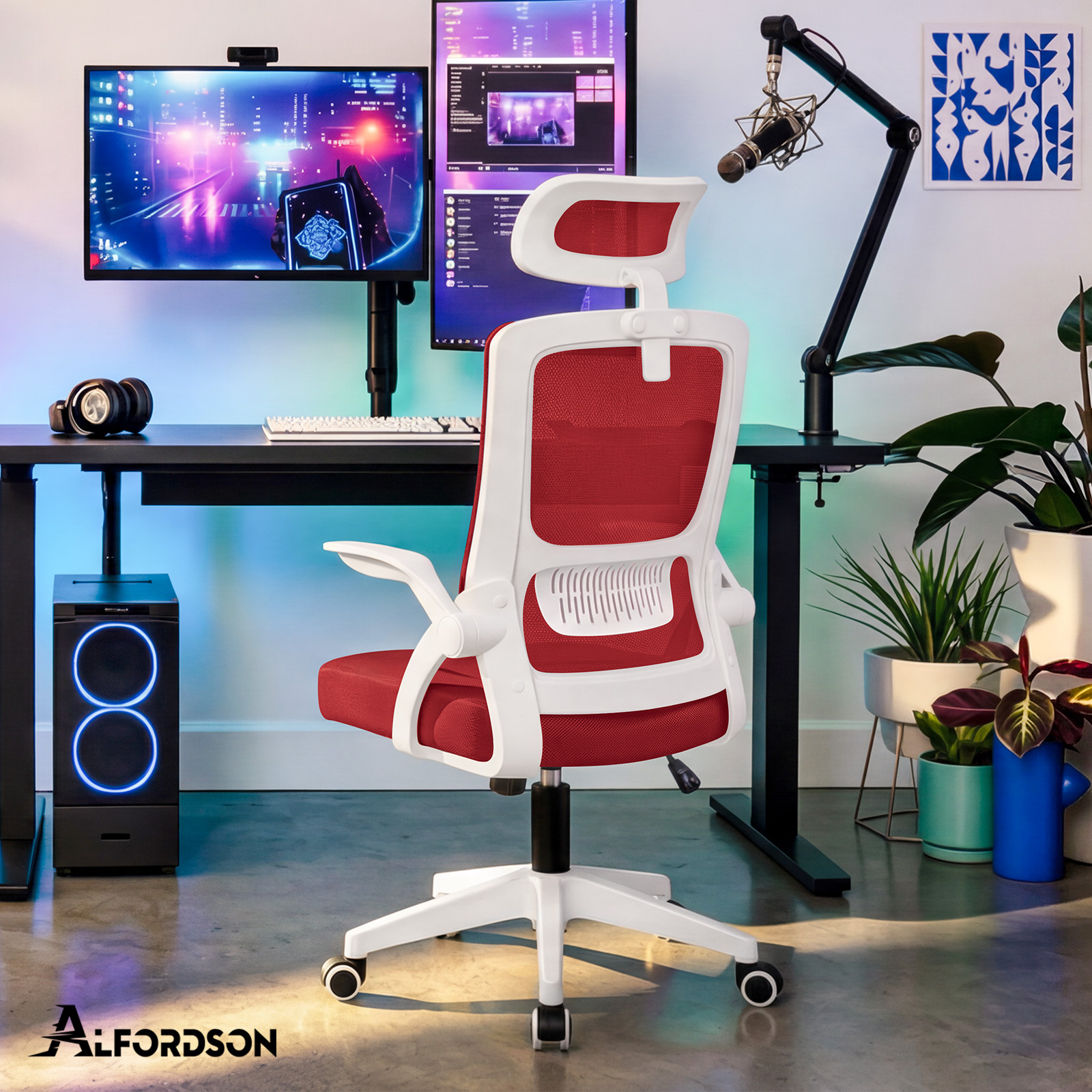 Ein weiß-roter ergonomischer Bürohochstuhl vor einem Schreibtisch mit zwei Monitoren und Pflanzen im Hintergrund.