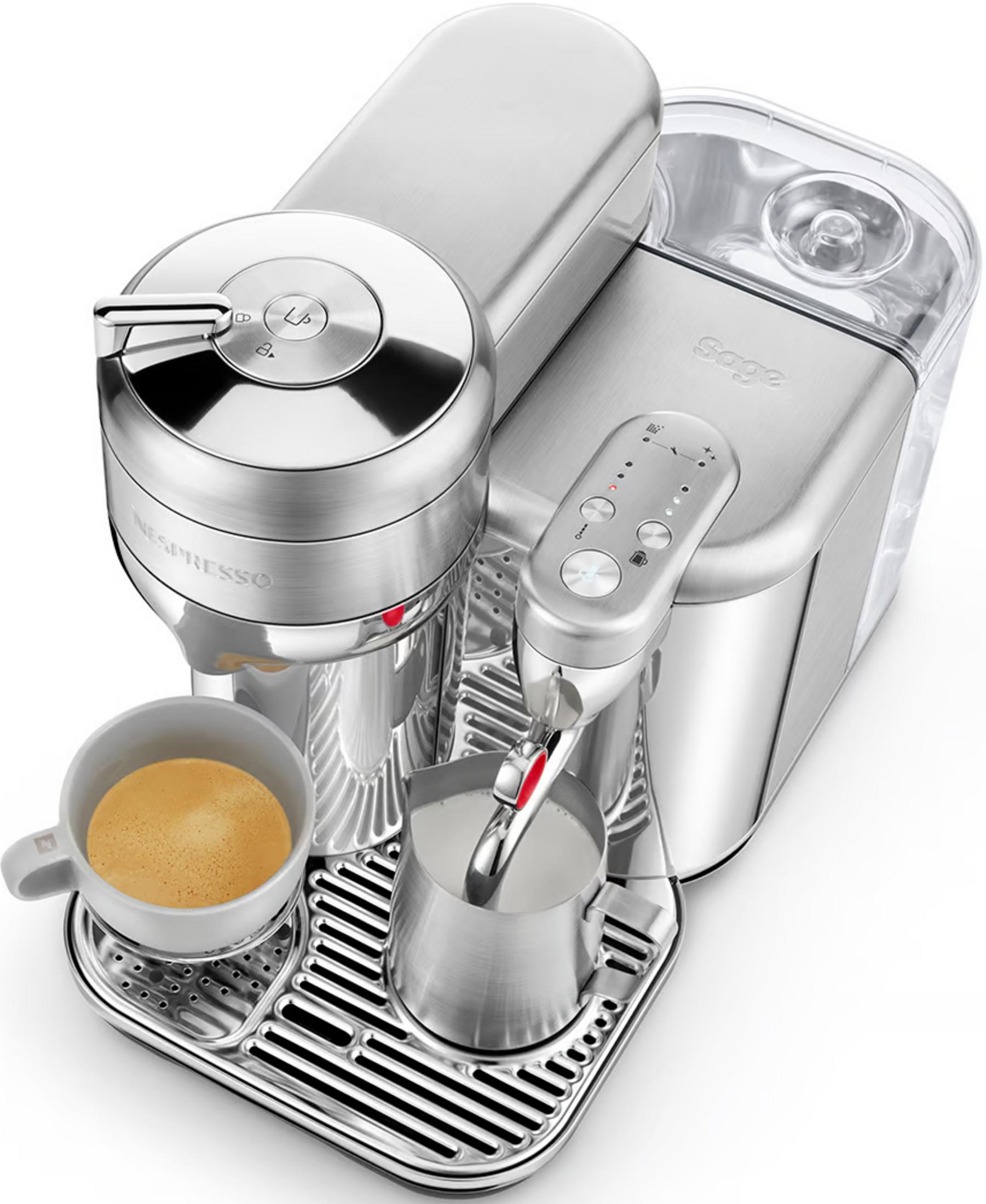 Une machine à café Nespresso argentée avec une tasse de café et un pichet à lait sur le plateau d'égouttage.