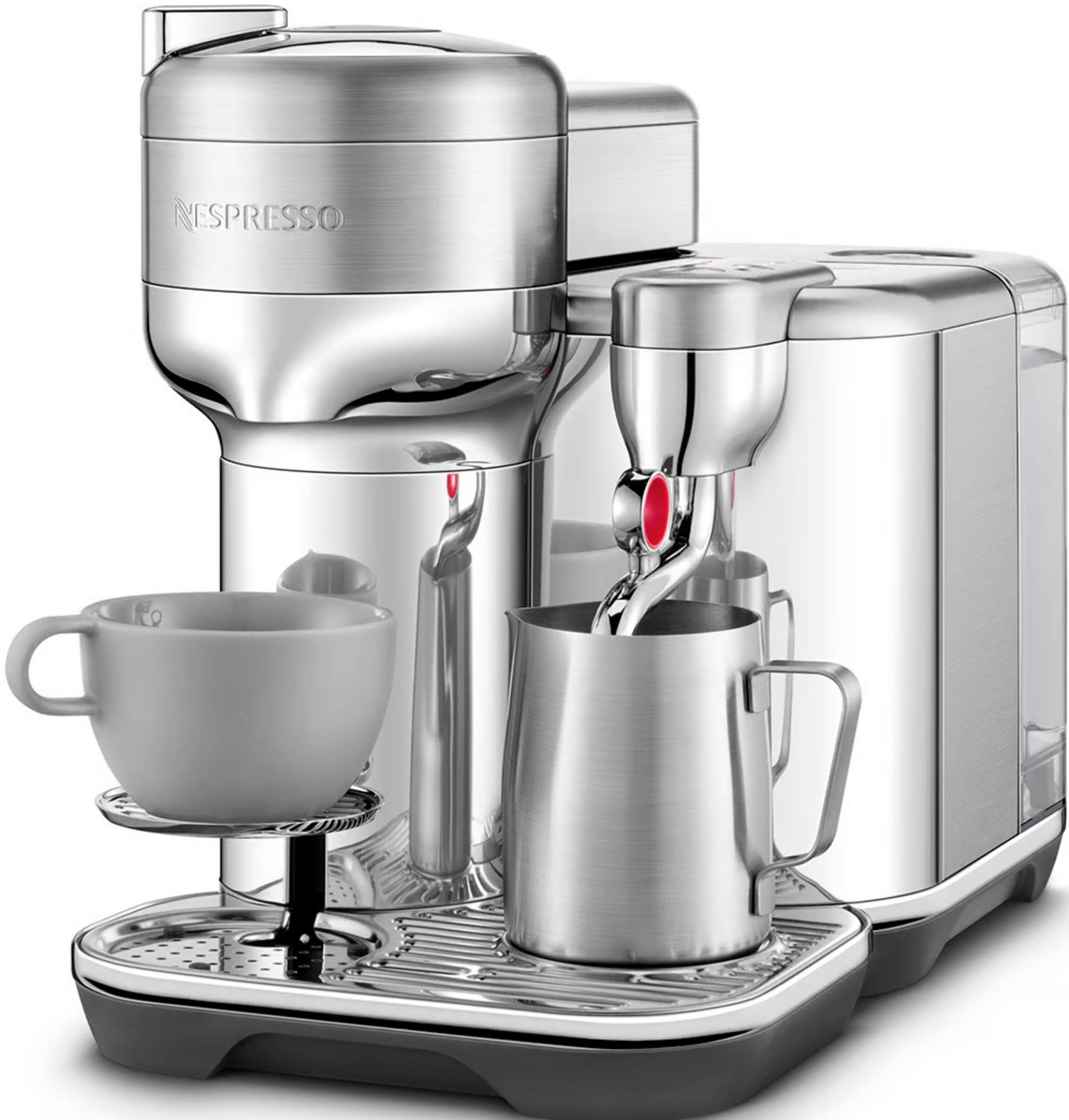 Une machine à café Nespresso argentée avec une tasse grise et un pichet à lait sur un plateau.