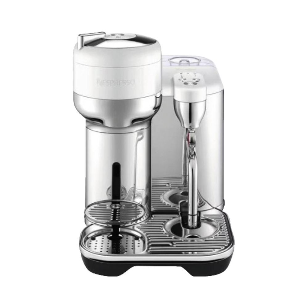 Une cafetière Nespresso blanche et argentée posée sur une surface blanche.