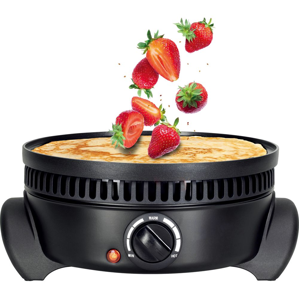 Frische Erdbeeren fallen auf einen Crêpe in einer schwarzen Crêpe-Platte.
