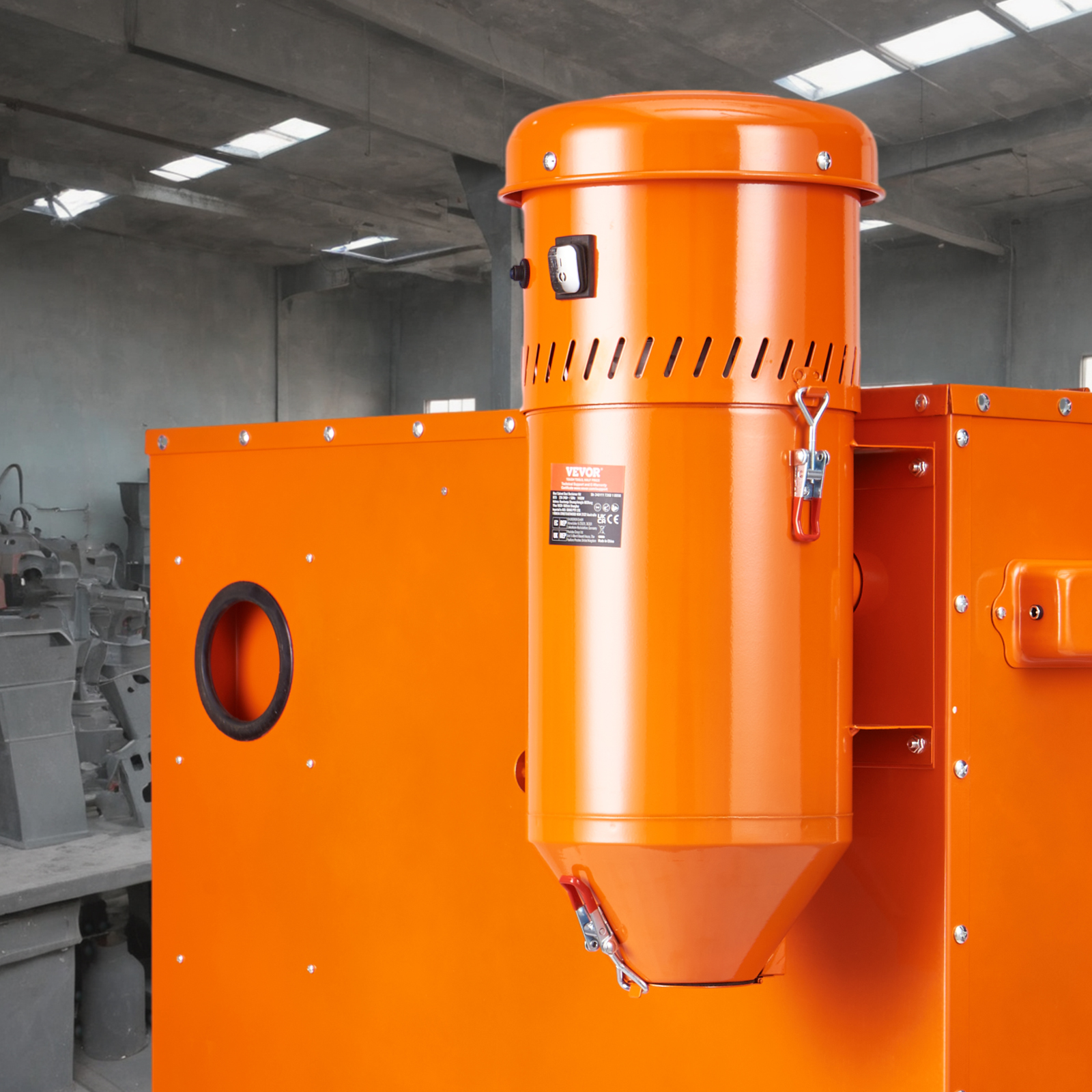Una máquina industrial naranja brillante con un filtro cilíndrico y cierres metálicos en una fábrica.