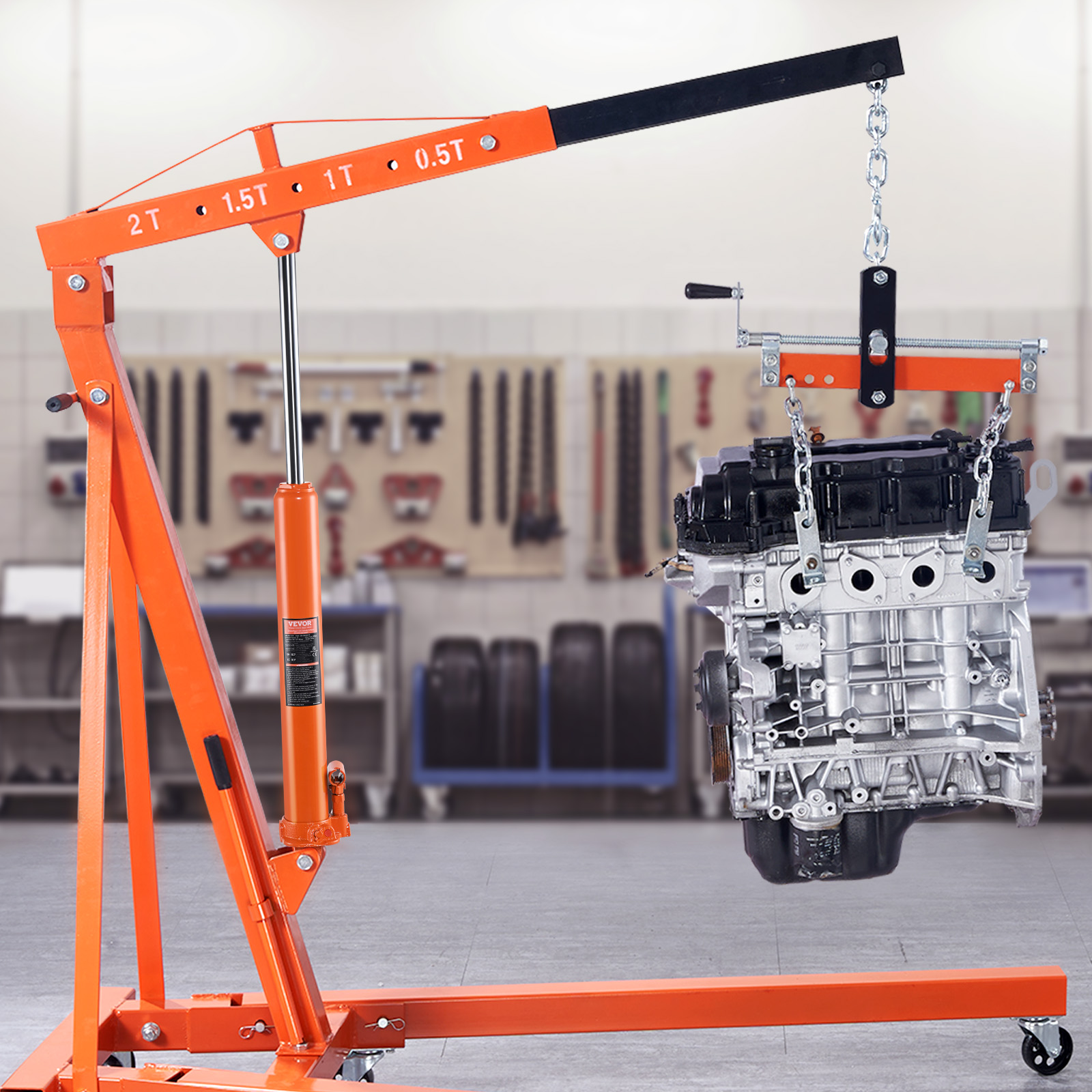 Una grúa de taller naranja levanta el motor de un coche en un taller.