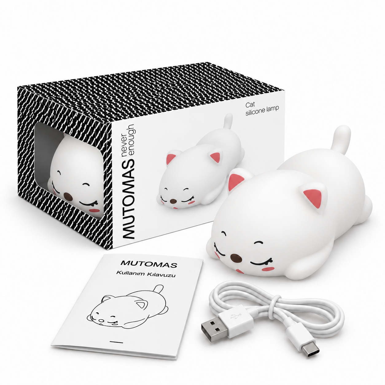 Beyaz silikon kedi lamba, kılavuz ve USB kablosuyla birlikte siyah-beyaz desenli kutusunun önünde duruyor.