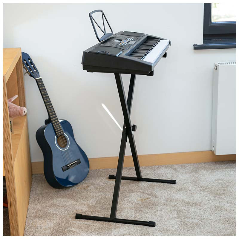 Ein elektronisches Keyboard auf einem Ständer und eine blaue Gitarre stehen in einem hellen Raum auf Teppichboden.