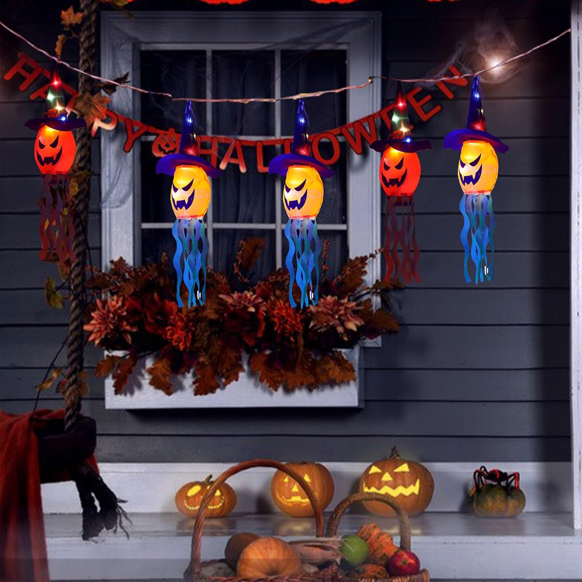 Leuchtende Halloween-Hexenhut-Geisterlaternen hängen auf einer Veranda mit Kürbissen und Herbstblättern.