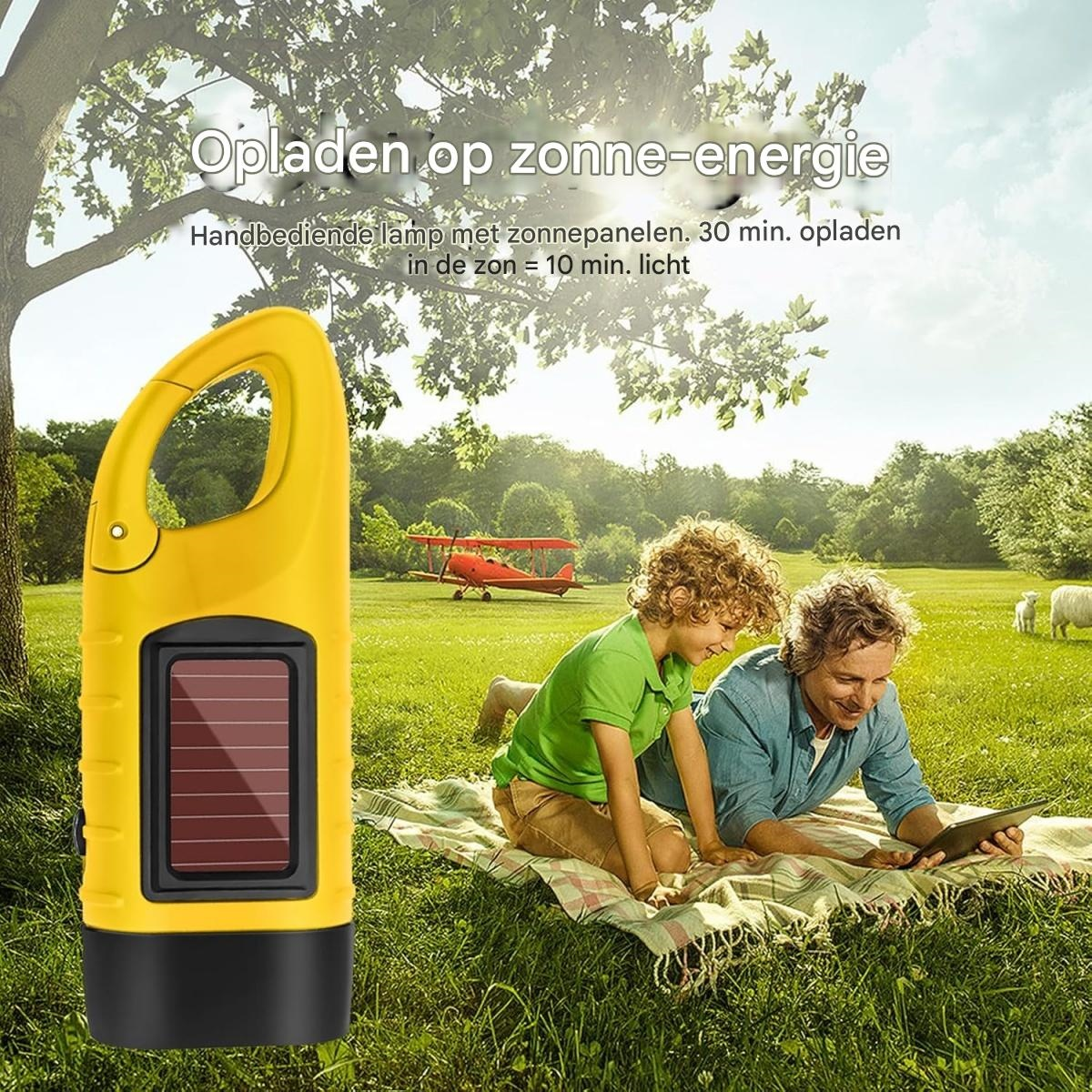 Eine gelbe Solarlampe im Vordergrund, während ein Kind und ein Mann auf einer Wiese picknicken.