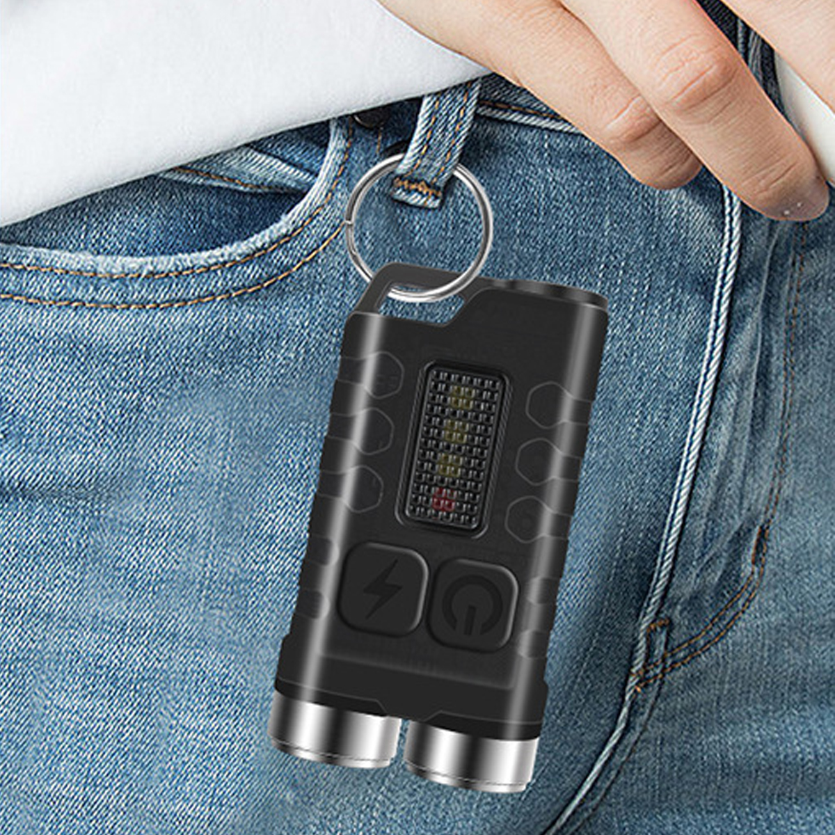 Eine kleine schwarze Taschenlampe hängt an einer Gürtelschlaufe von Blue Jeans.