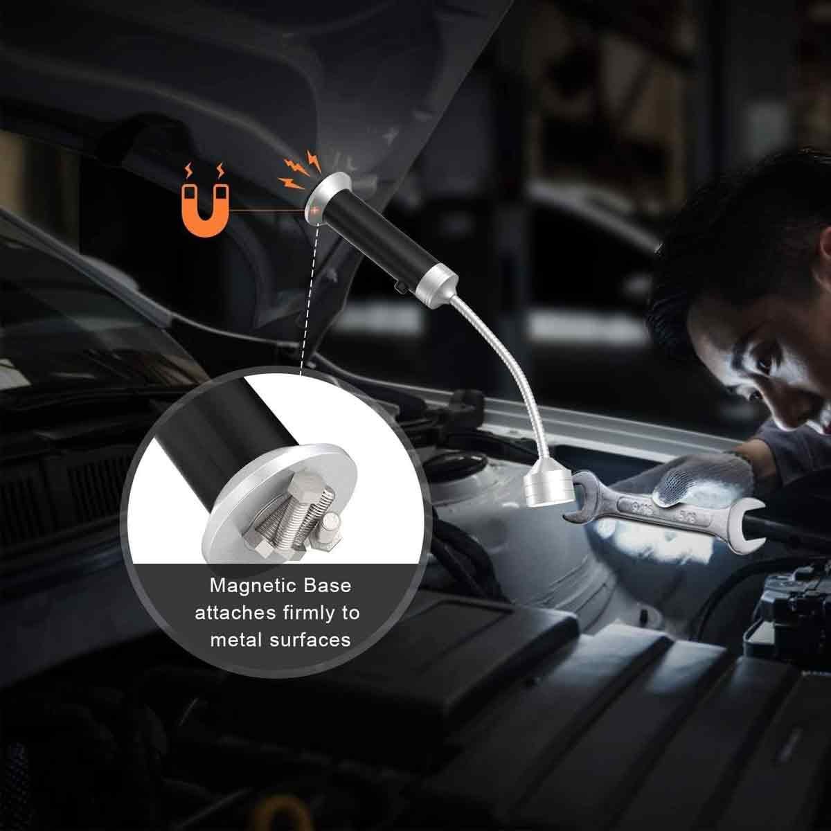 Ein Mechaniker repariert ein Auto, während eine Magnethalterung eine Inspektionslampe an der Motorhaube hält.