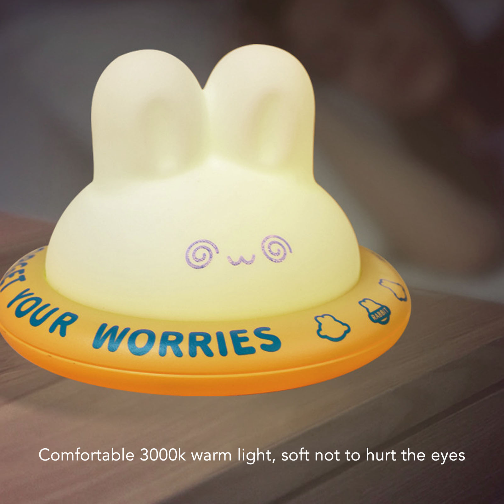 Ein gelbes Hasen-Nachtlicht mit der Aufschrift GET YOUR WORRIES auf einem Holztisch.