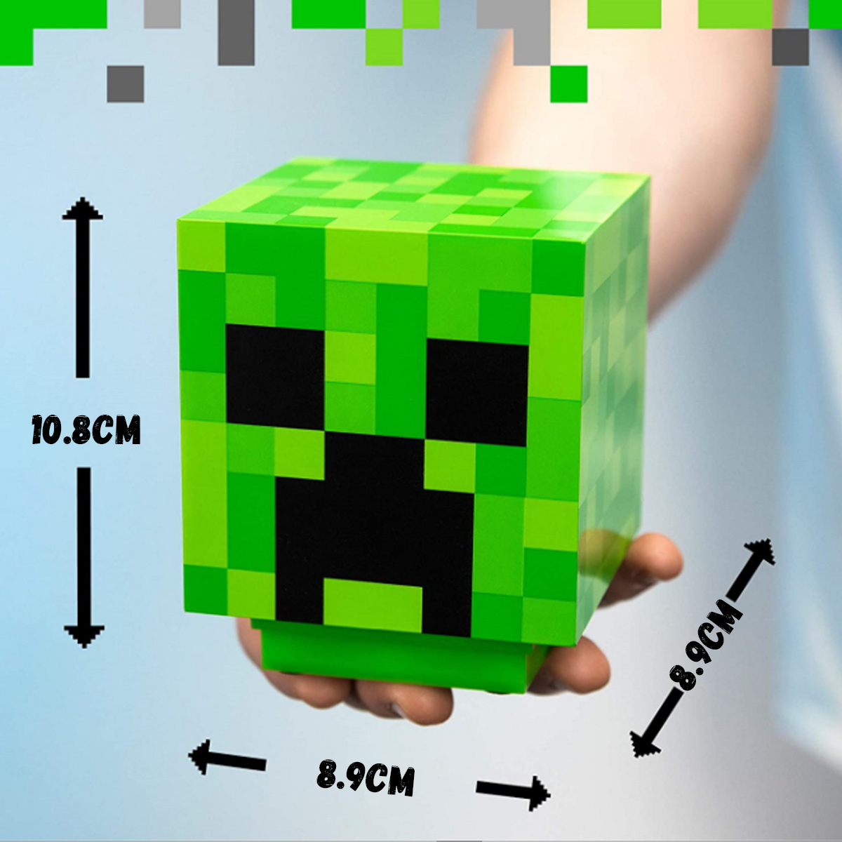 Eine Hand hält eine grüne Minecraft-Creeper-Lampe mit Maßpfeilen für Höhe und Breite.