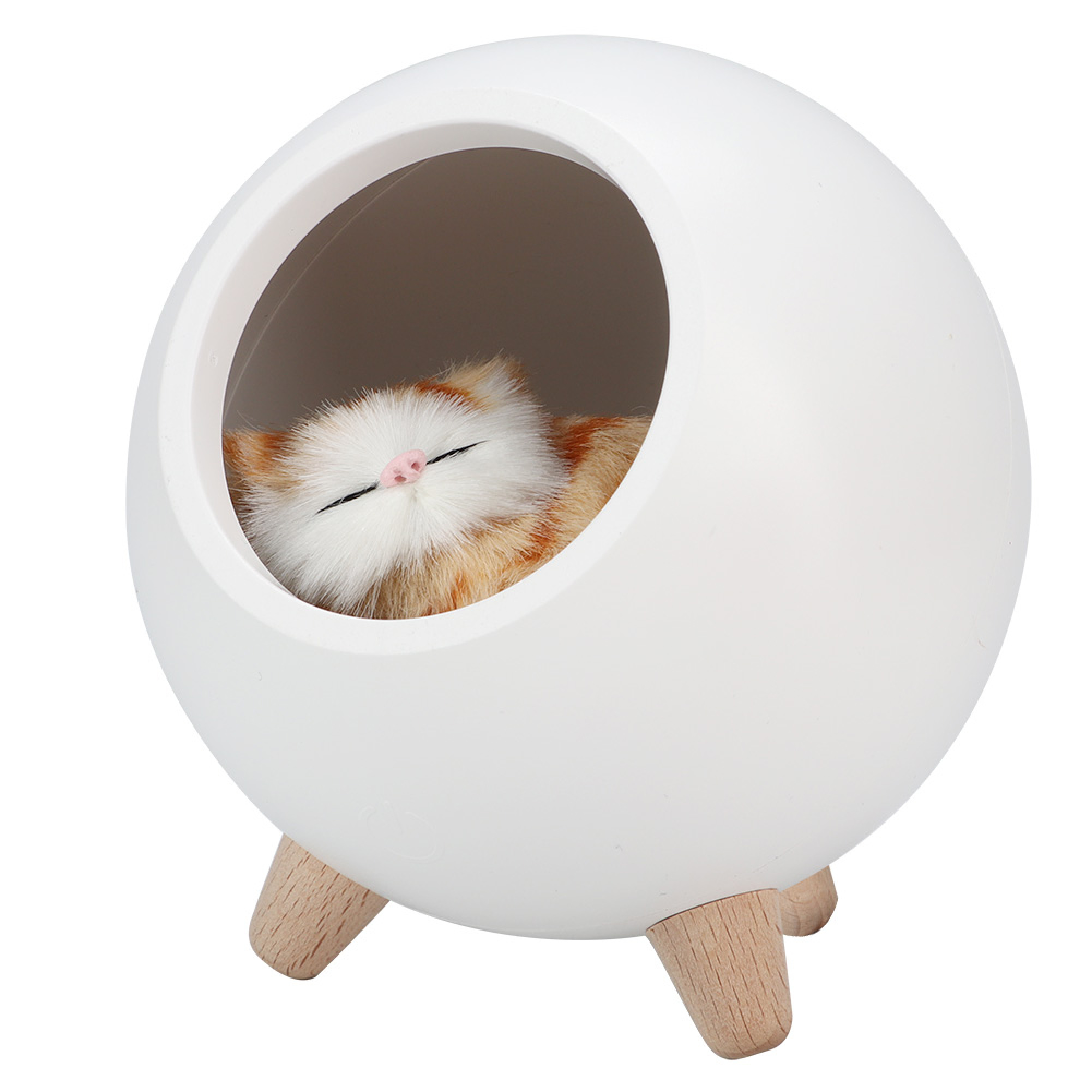 Eine schlafende Spielzeugkatze ruht in einer runden weißen Schale mit Holzbeinen vor weißem Hintergrund.