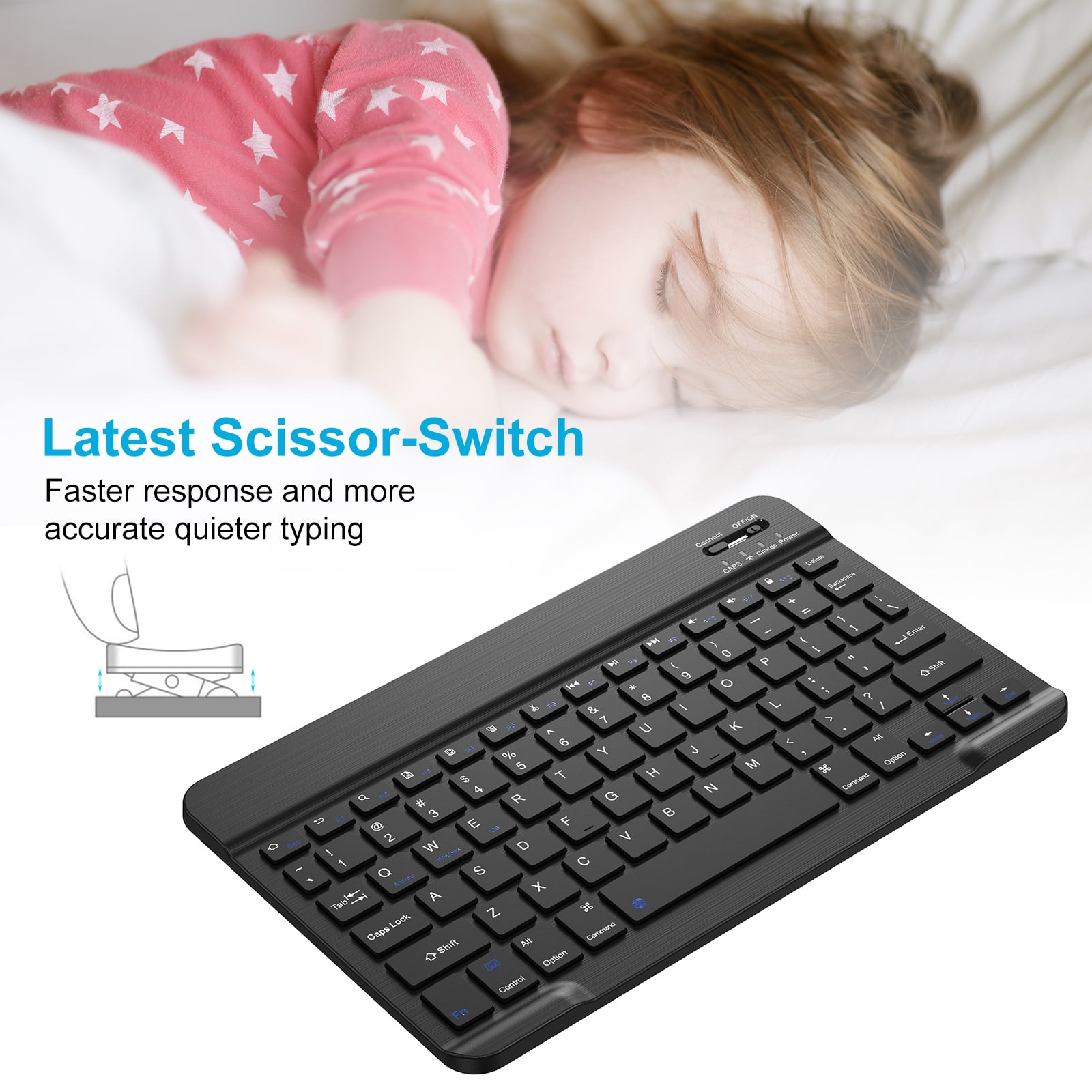 Eine schwarze kabellose Tastatur mit Scheren-Tasten unter einem schlafenden Kind.