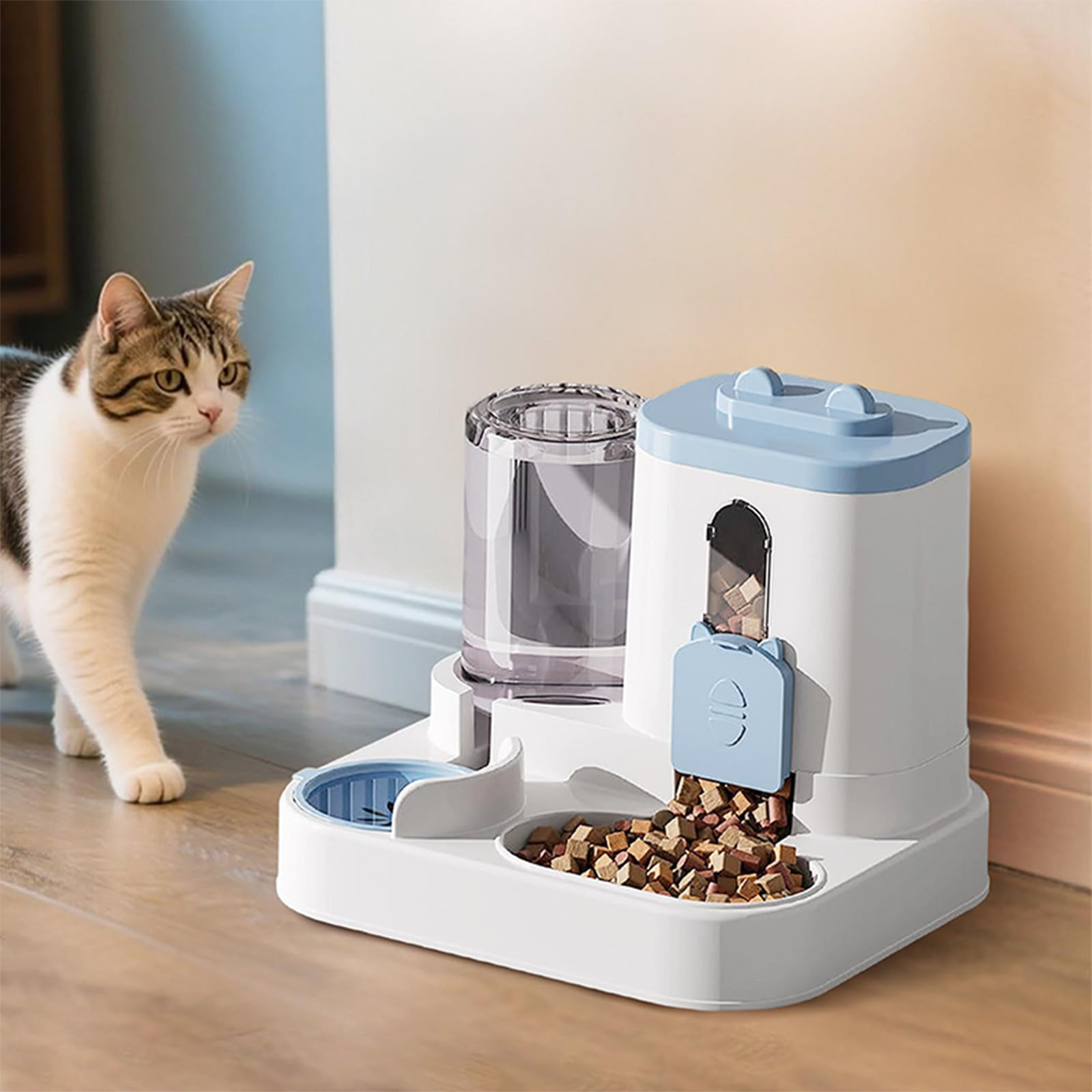 Eine Katze nähert sich einem automatischen Futter- und Wasserspender in Weiß und Blau auf einem Holzboden.