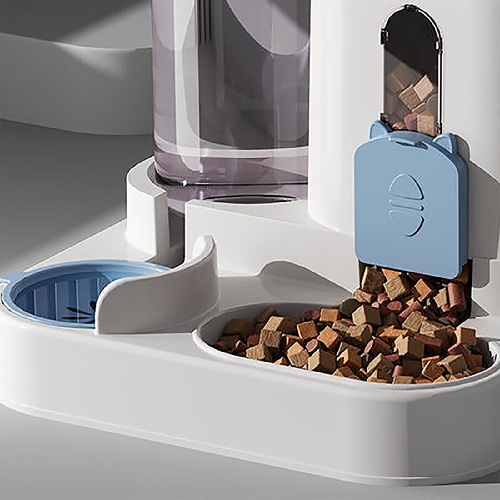 Ein weißer automatischer Haustierfutterautomat mit Wassernapf und Trockenfutter.