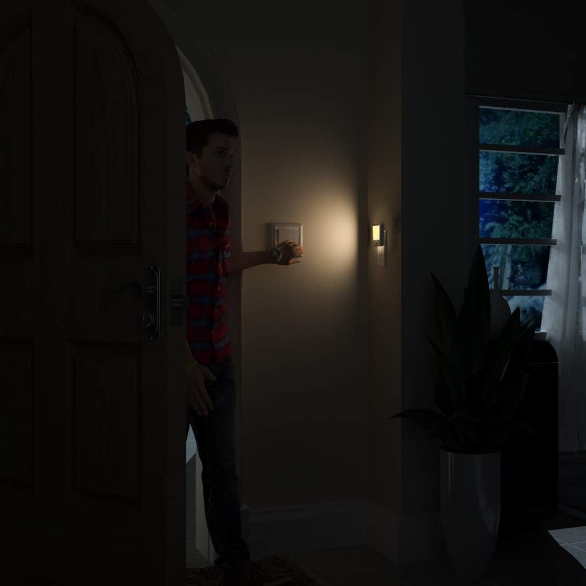 Ein Mann im karierten Hemd betritt abends einen dunklen Flur und schaltet das Licht ein.