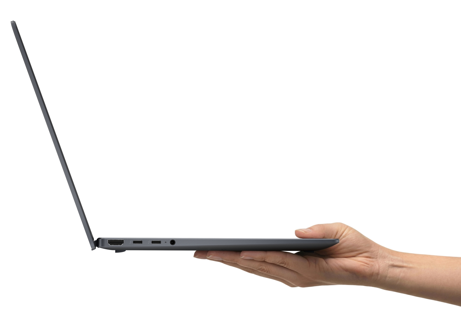 Una mano tiene il lato di un computer portatile grigio, aperto e sottile contro uno sfondo bianco.