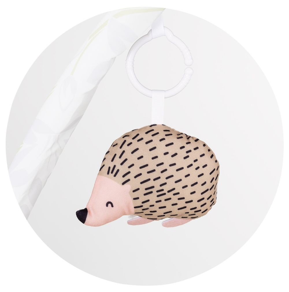 Ein Plüsch-Igel-Spielzeug hängt an einem weißen Plastikring vor hellm Hintergrund.