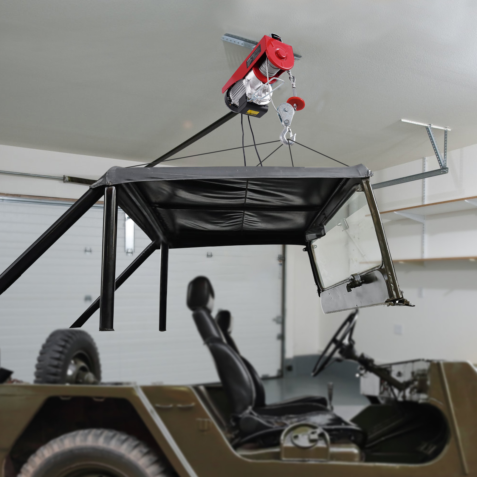 Un polipasto eléctrico rojo levanta la capota y el parabrisas de un jeep.