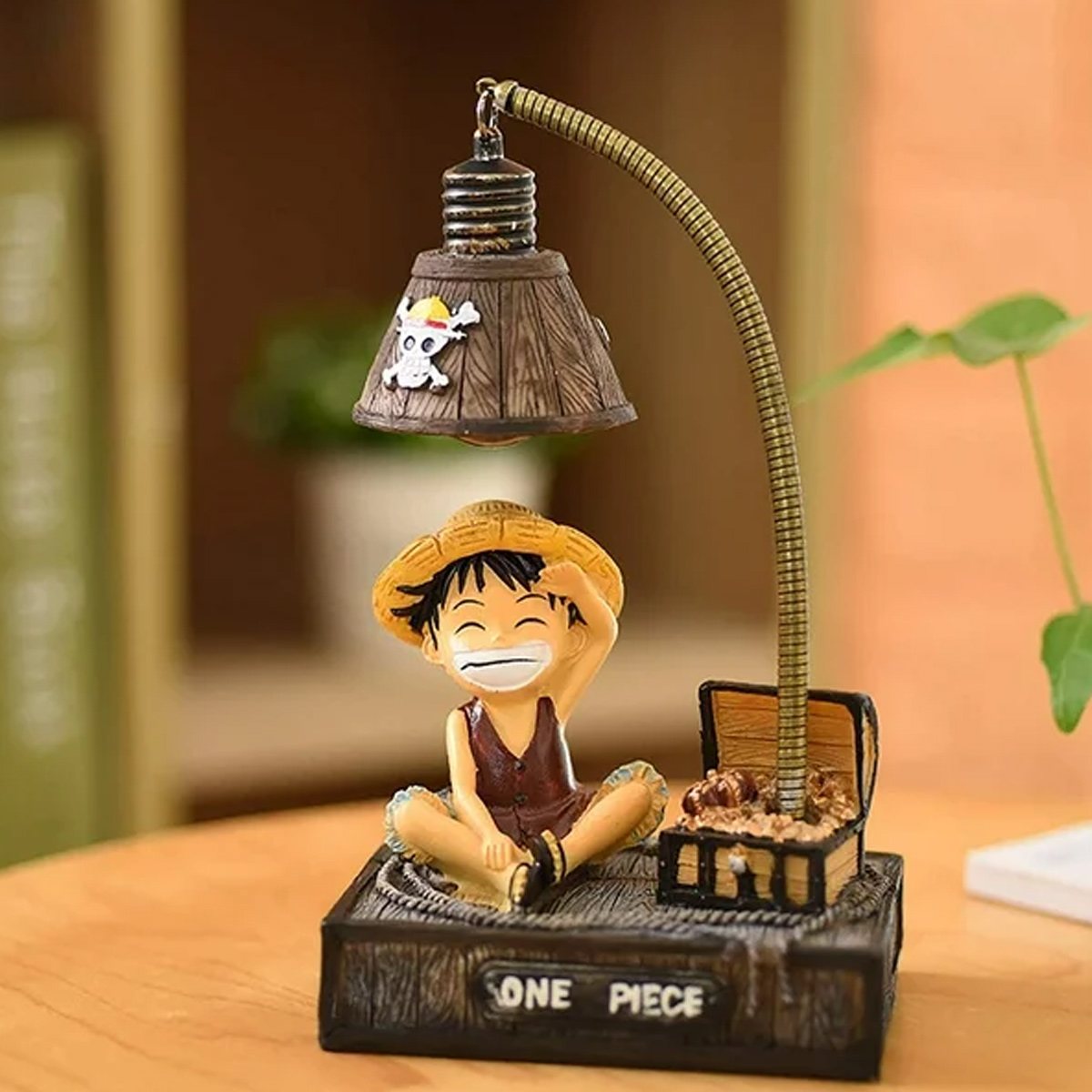 Eine One Piece-Figur sitzt unter einer Lampe mit einem Totenkopfsymbol und einem offenen Schatzkasten daneben.
