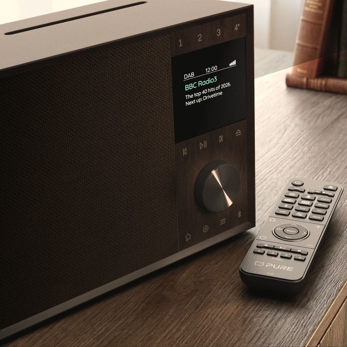 Ein hölzernes DAB-Radio mit Display und Drehknopf steht auf einem Tisch, daneben liegt eine schwarze Fernbedienung.