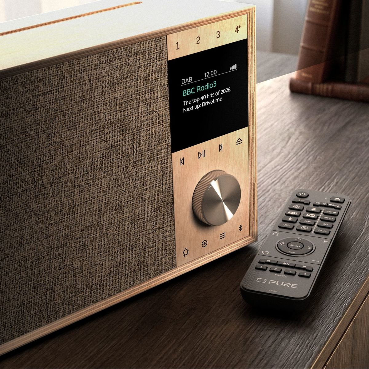 Ein Holzradio mit Digitaldisplay und Stoffgitter steht auf einem dunklen Holztisch neben einer schwarzen Fernbedienung.