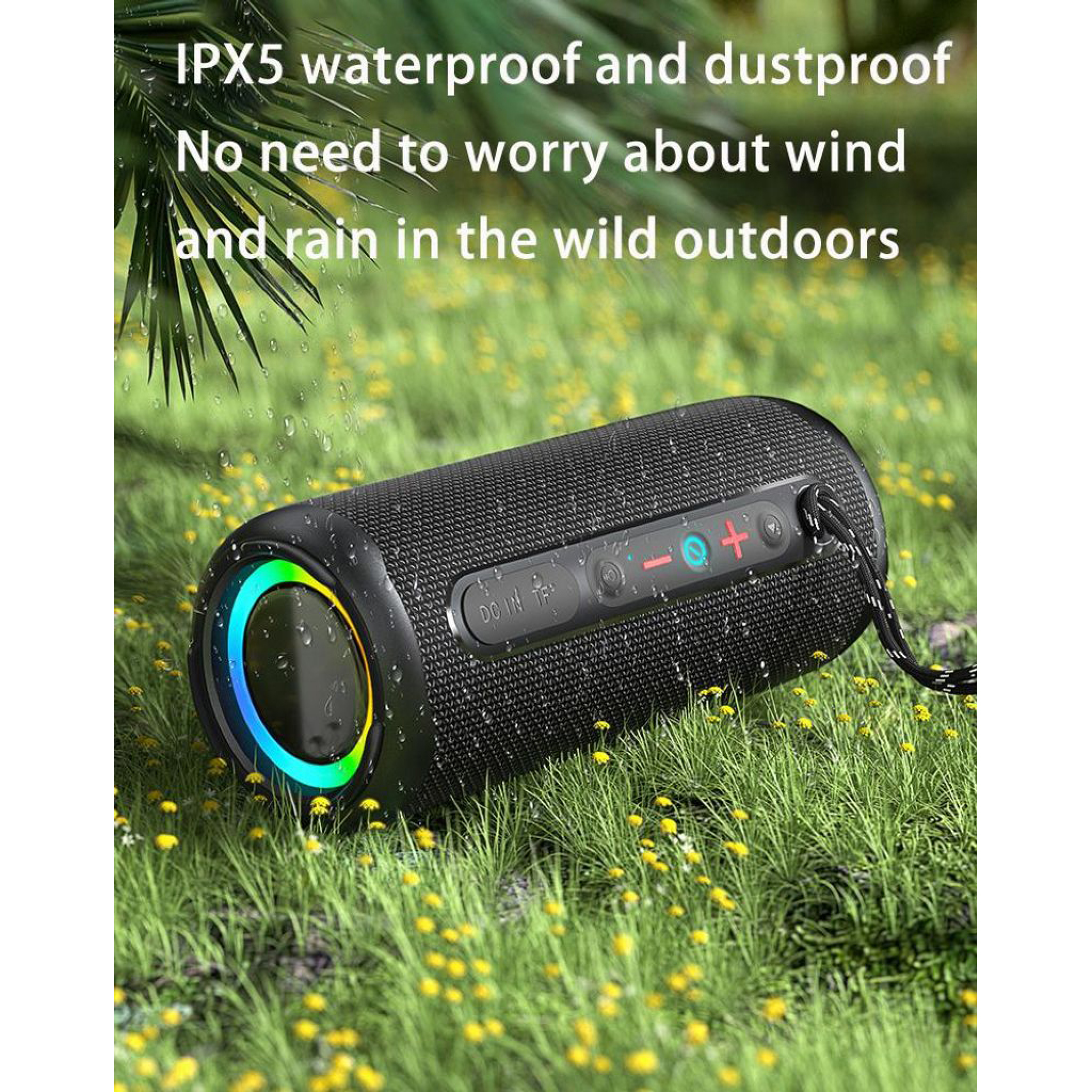 Ein schwarzer, wasserdichter Bluetooth-Lautsprecher auf einer grünen Wiese mit kleinen gelben Blumen.