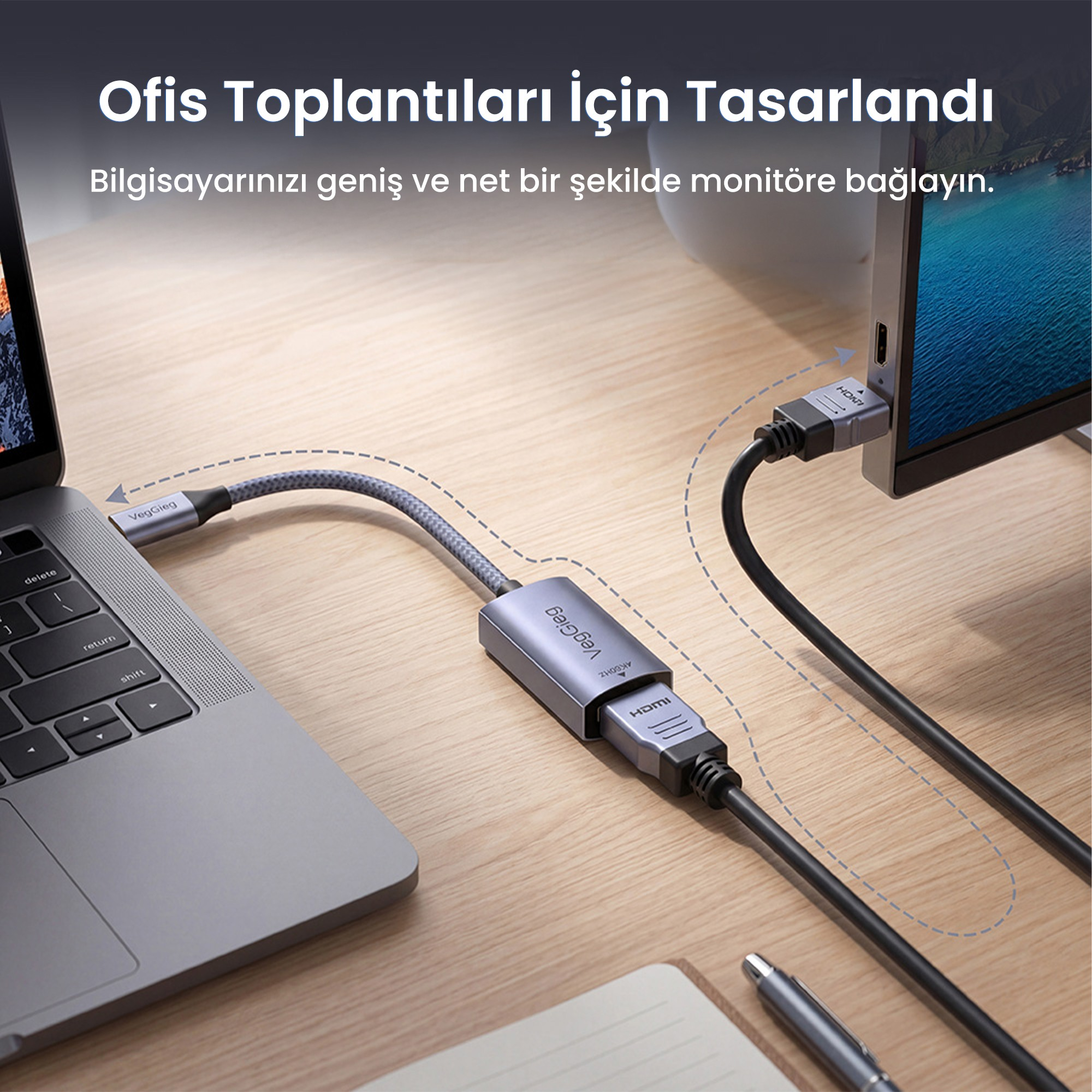 Gri bir adaptör, ahşap masa üzerinde HDMI kablosuyla bir dizüstü bilgisayarı harici monitöre bağlar.