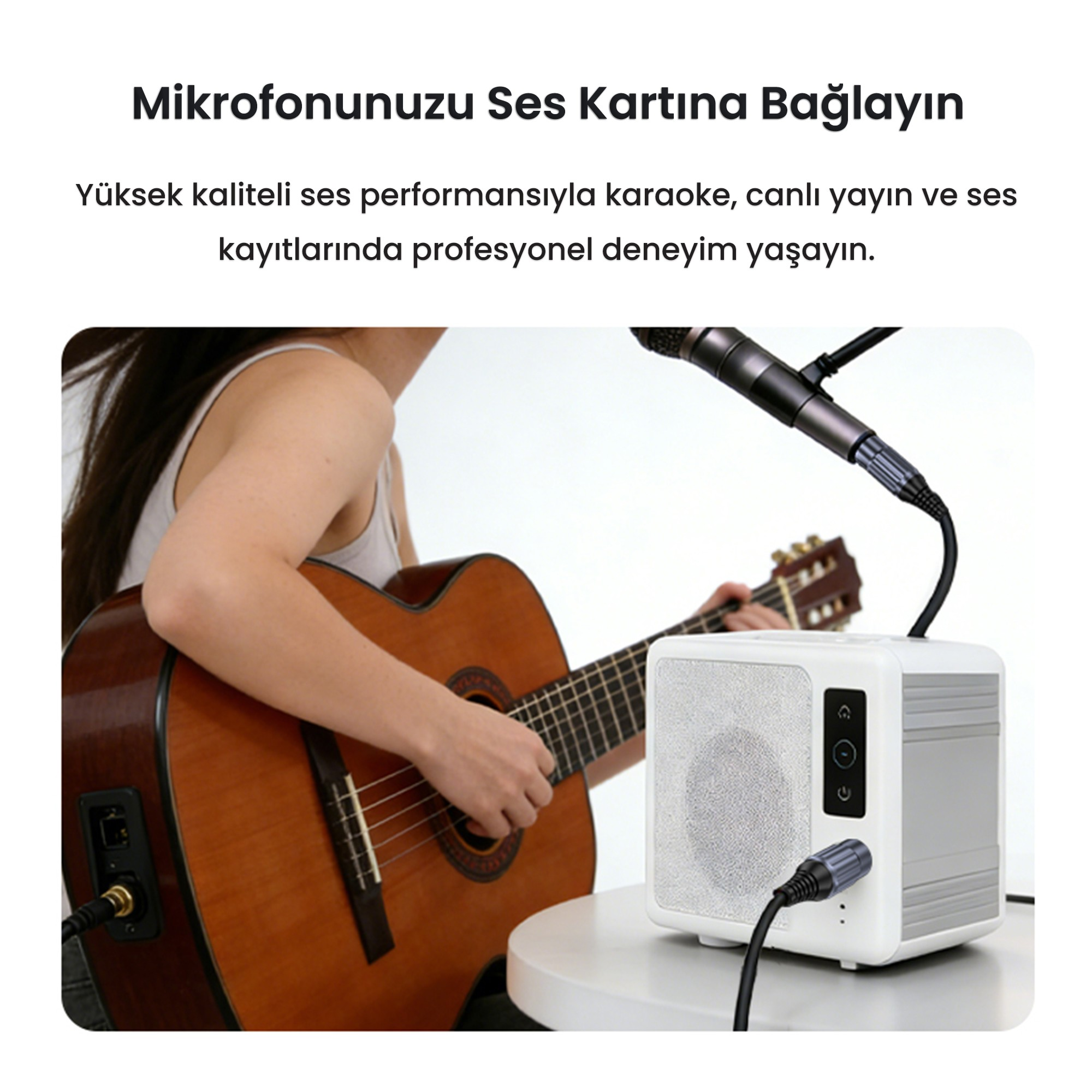 Bir kadın, masadaki mikrofonlu ses sisteminin yanında akustik gitar çalıyor.