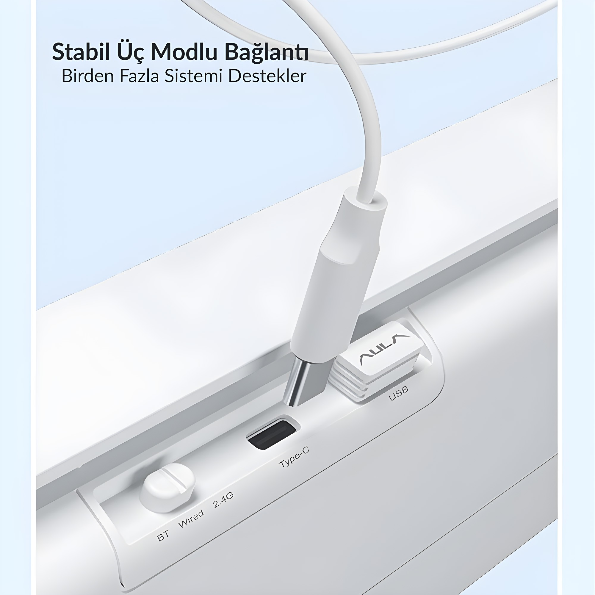 Beyaz bir Type-C kablosu bağlantı noktasına takılıyor, yanında küçük bir USB alıcı ve mod anahtarı var.