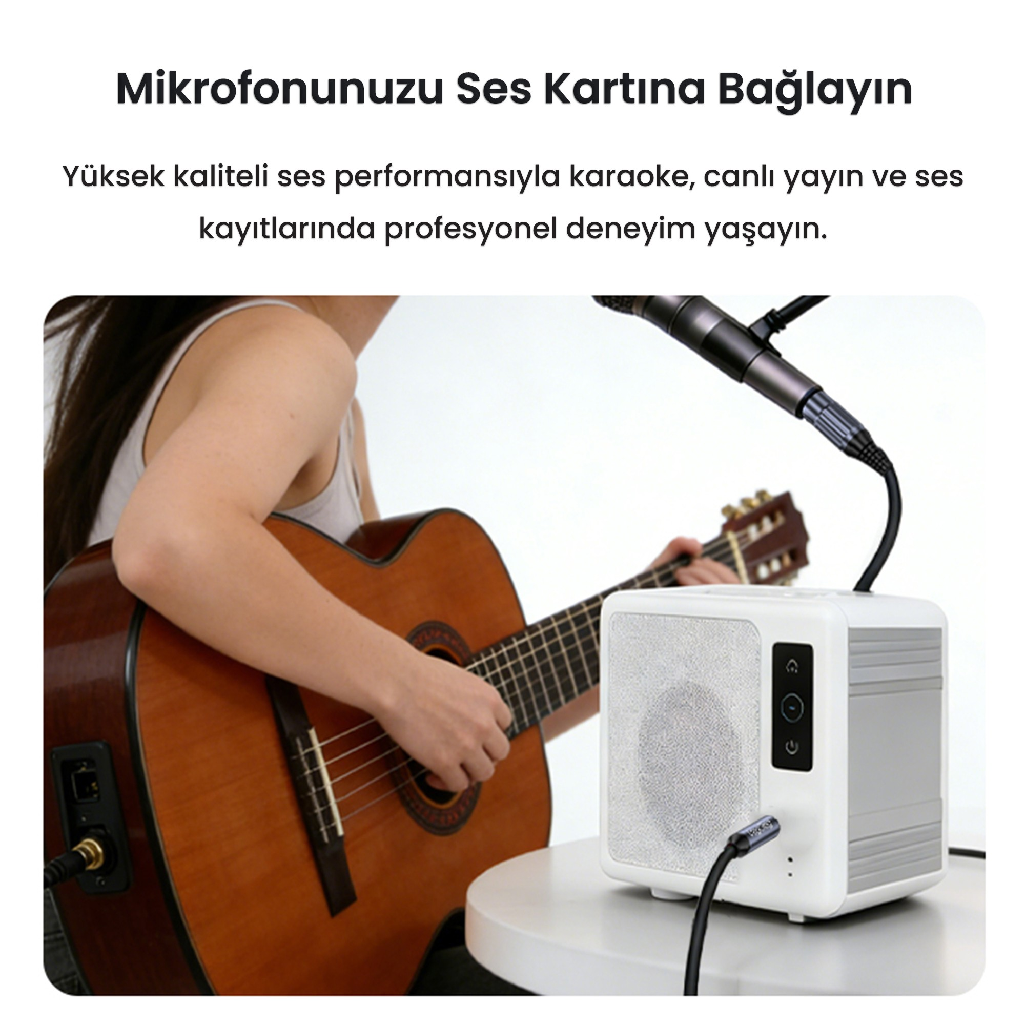 Bir kadın, mikrofonlu beyaz ses kartının yanında gitar çalıyor.