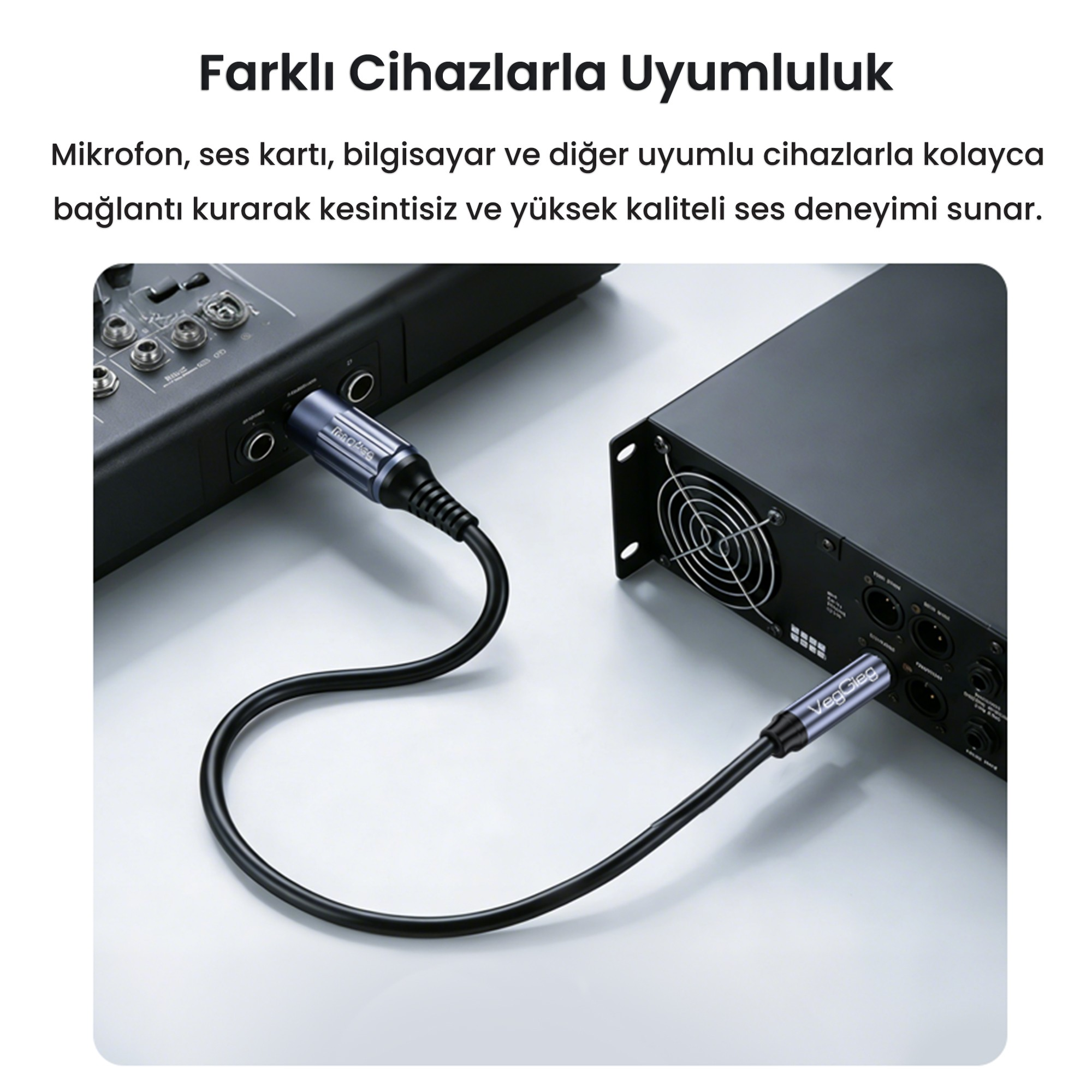 Gri bir yüzeyde iki gümüş rengi ses cihazını birbirine bağlayan siyah bir ses kablosu.