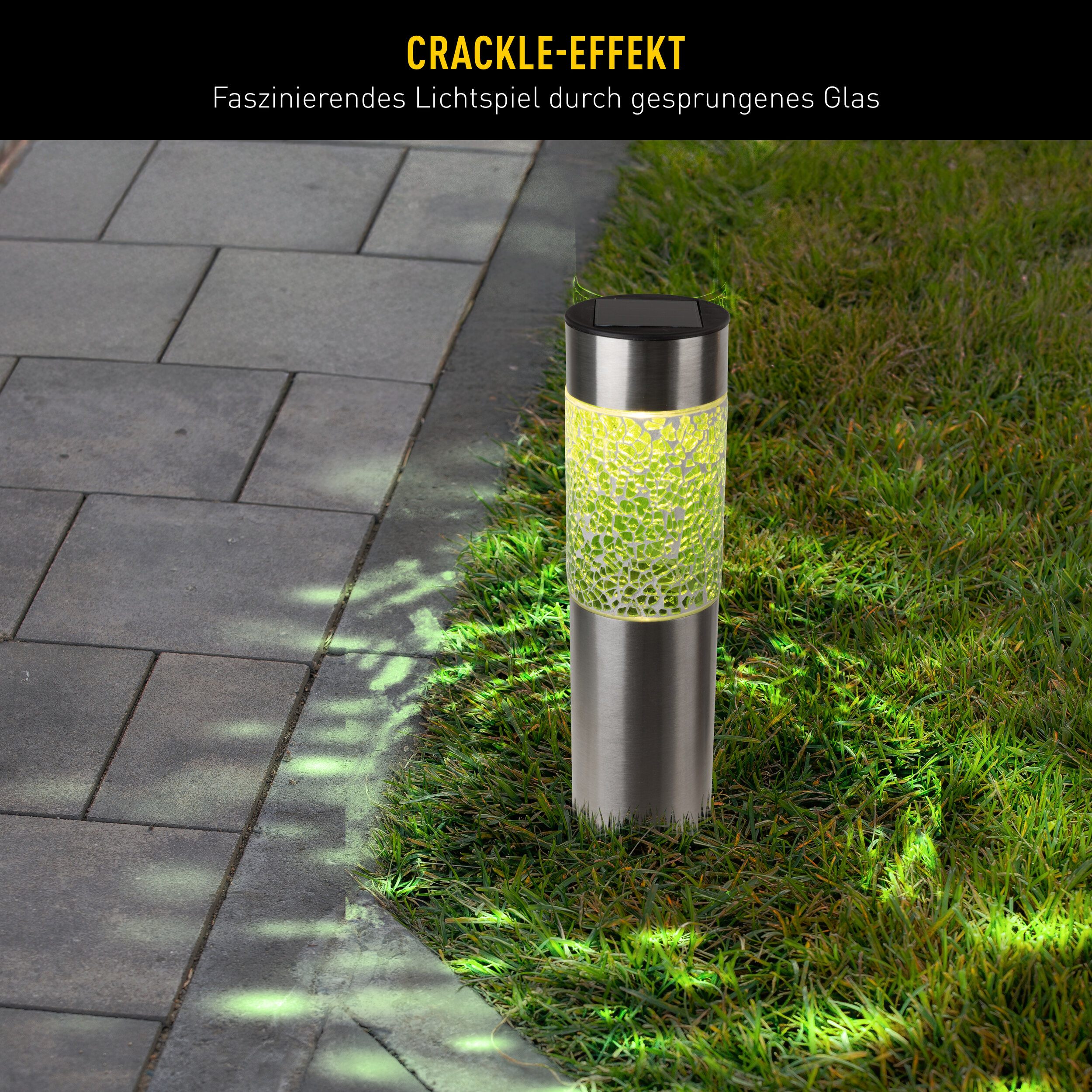 Solar-Gartenleuchte mit Rissglas-Effekt steht auf Rasen neben grauen Pflastersteinen.