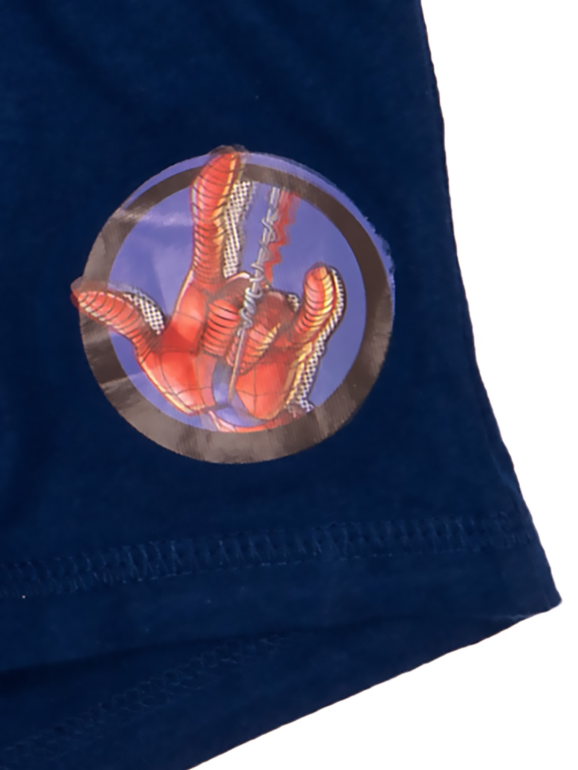 Ein blaues Textil mit einem runden Aufnäher, der eine rot-schwarze Spiderman-Hand zeigt.