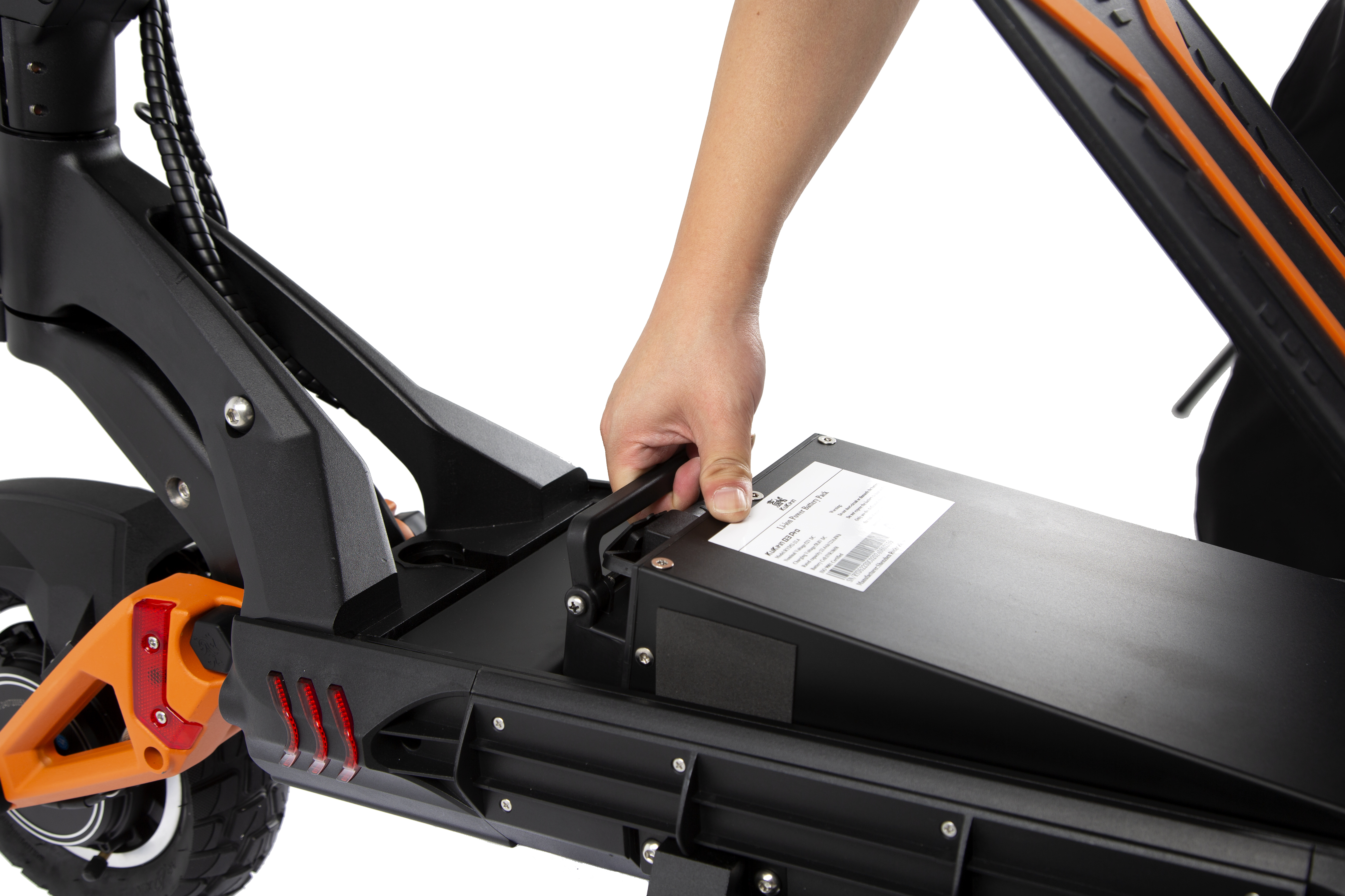 Una mano estrae il pacco batteria da un monopattino elettrico nero con dettagli arancioni.