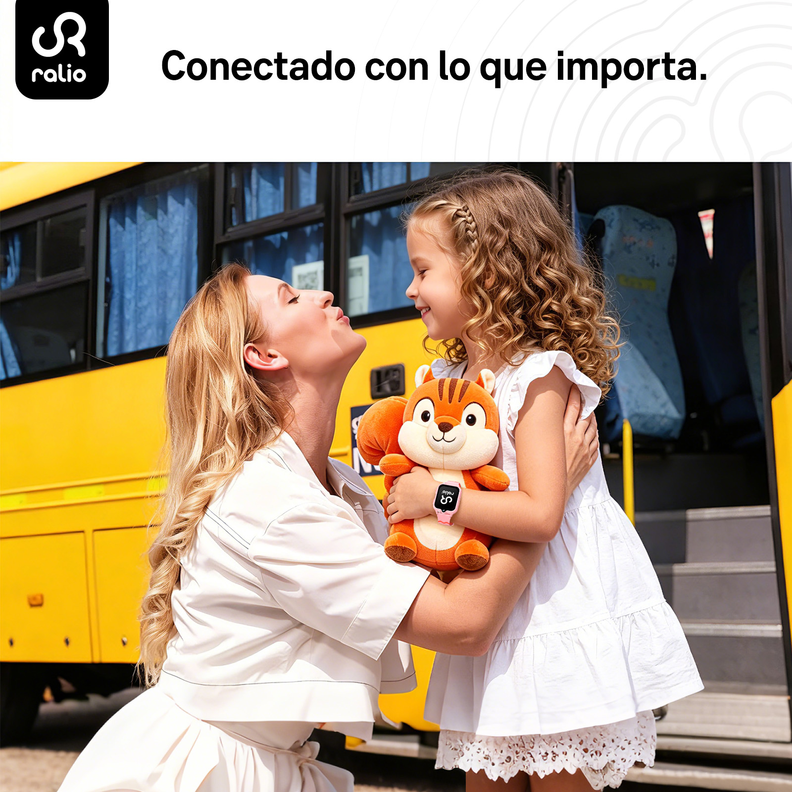 Una madre abraza a su hija sosteniendo un peluche de ardilla frente a un autobús amarillo.