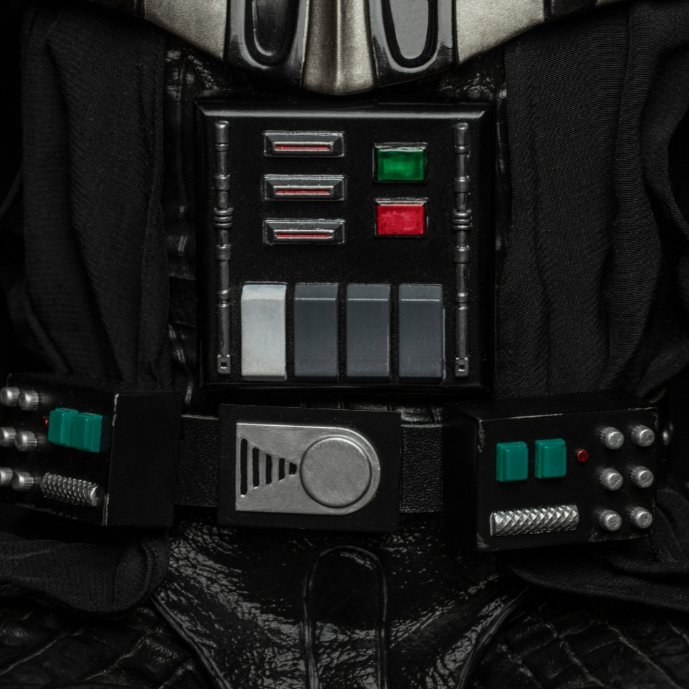 Primo piano del petto e della cintura di Darth Vader con pannelli di controllo, pulsanti e tessuto.