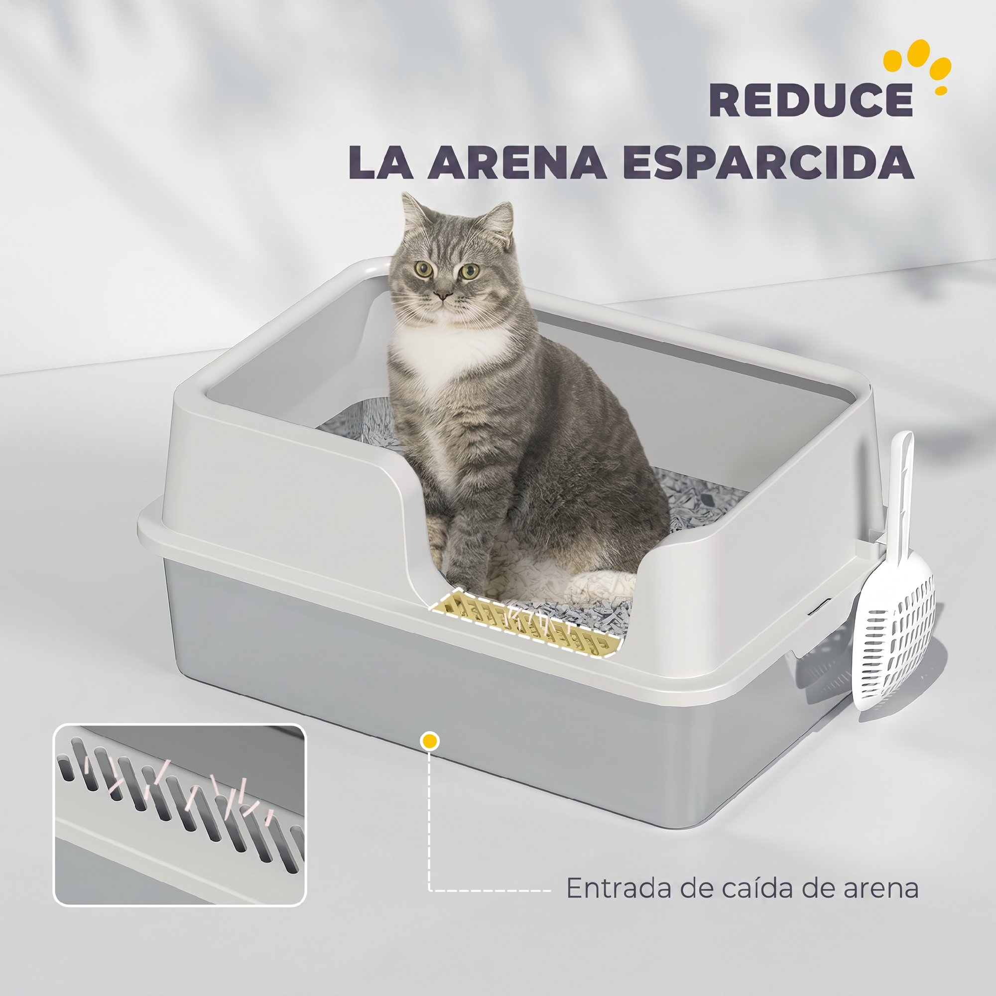 Un gato gris y blanco se sienta dentro de una caja de arena gris con pala.