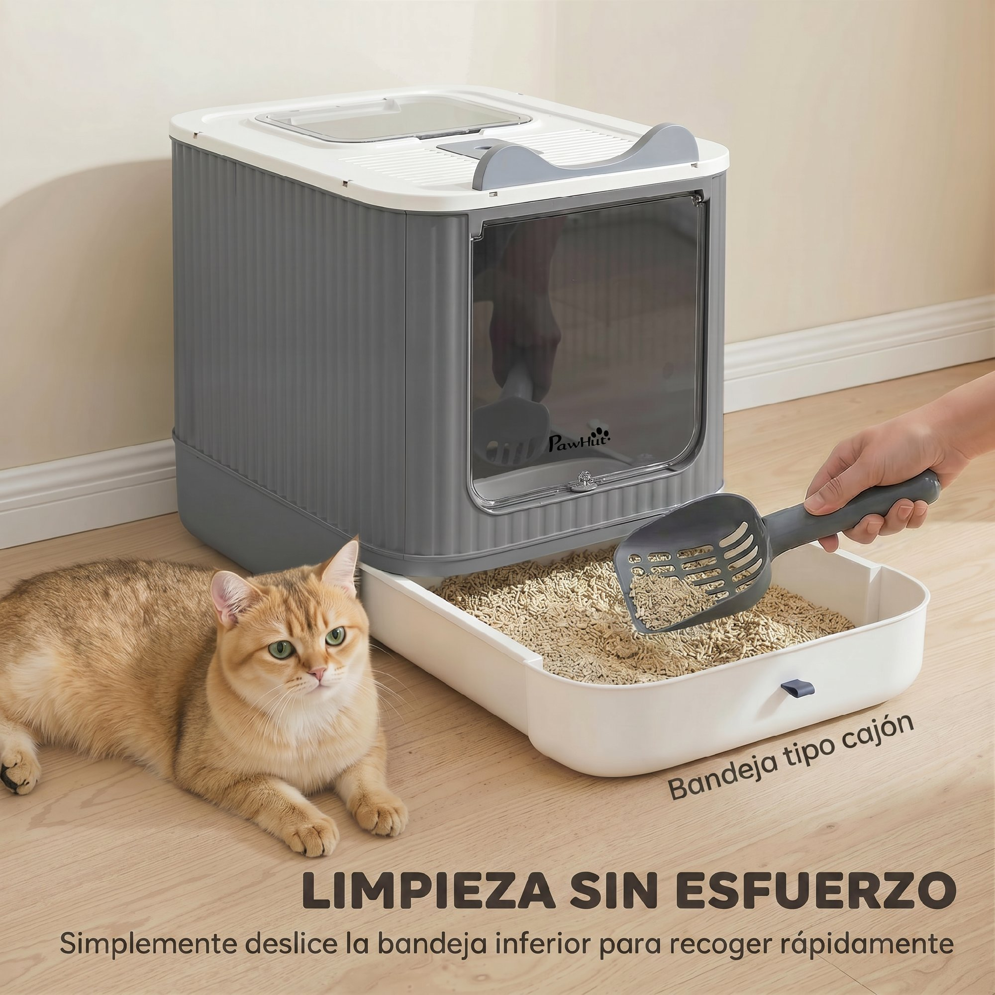 Un arenero para gatos gris con bandeja extraíble y un gato naranja tumbado en el suelo de madera.