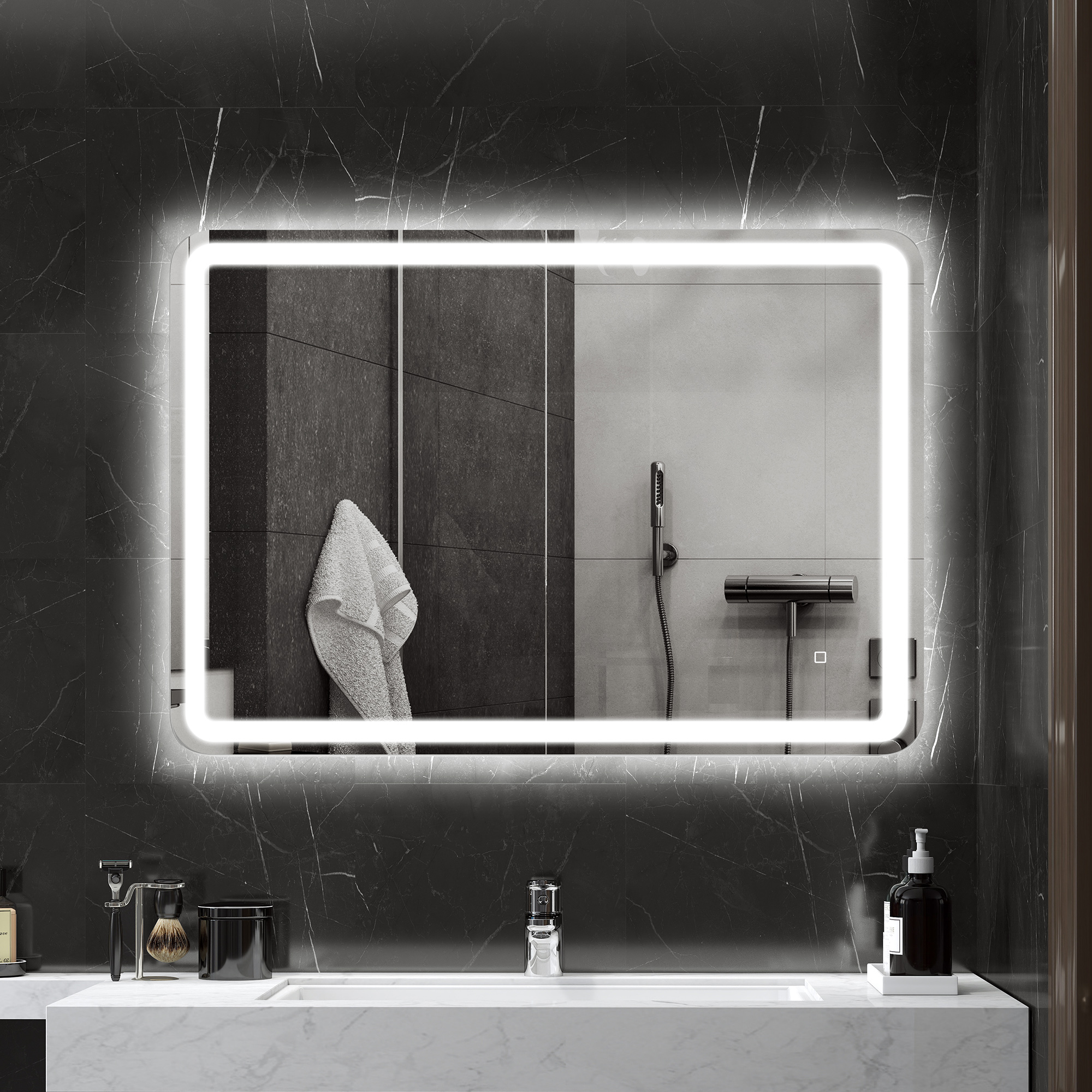 Un espejo iluminado cuelga en una pared de mármol oscuro sobre un lavabo moderno con accesorios de baño.