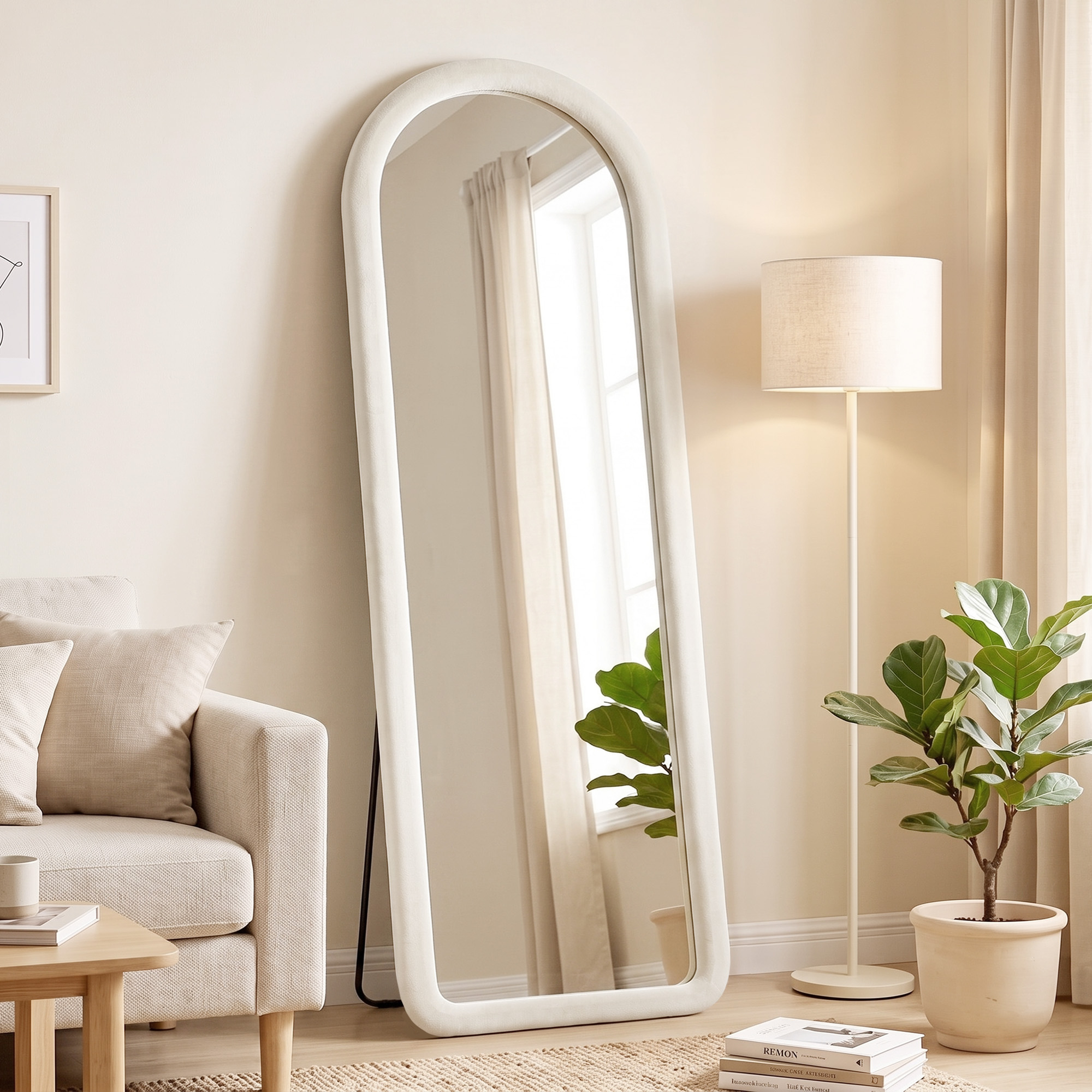 Un gran espejo de suelo arqueado blanco en una sala de estar luminosa con una lámpara de pie y una planta.