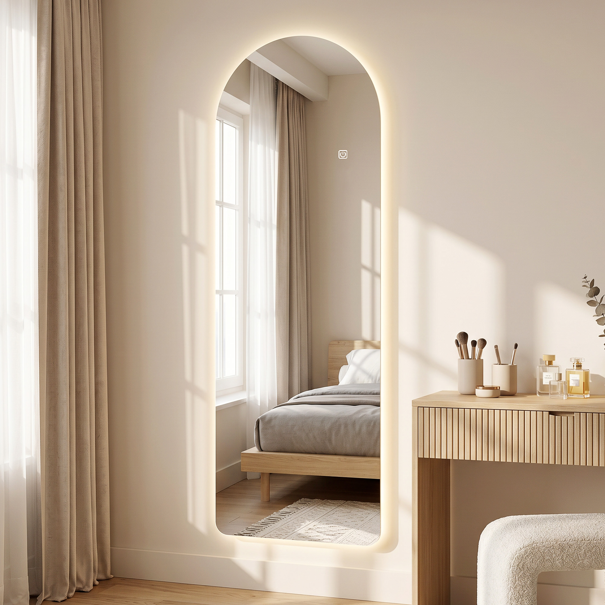 Un espejo de suelo LED arqueado contra una pared beige, que refleja un dormitorio con cama de madera.