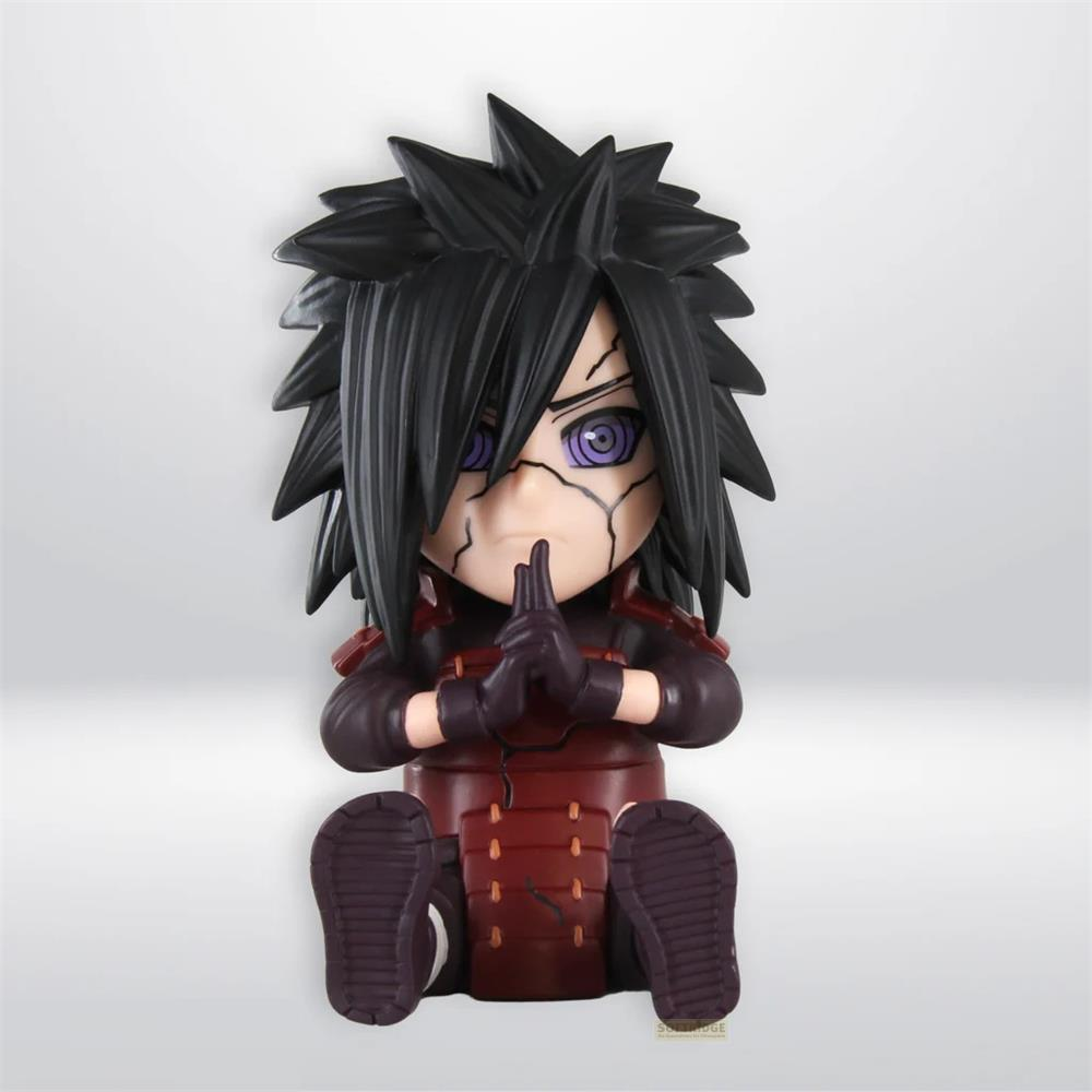 Estatuilla estilizada de un personaje de anime con pelo negro spiky, ojos púrpuras y armadura roja, sentada en una superficie blanca.