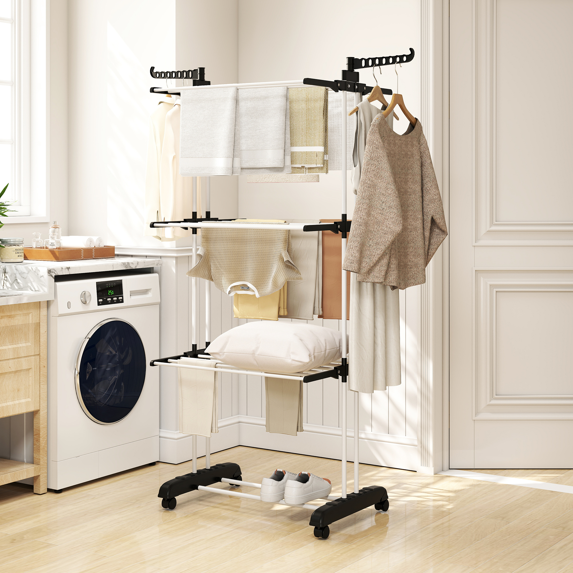 Un tendedero blanco con ropa y toallas cuelga en una habitación luminosa junto a una lavadora.