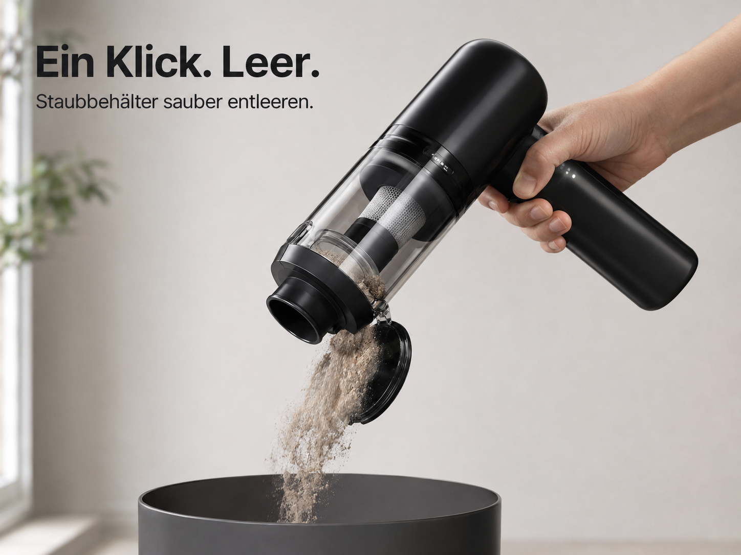 Ein Handstaubsauger entleert Schmutz per Knopfdruck in einen Eimer.