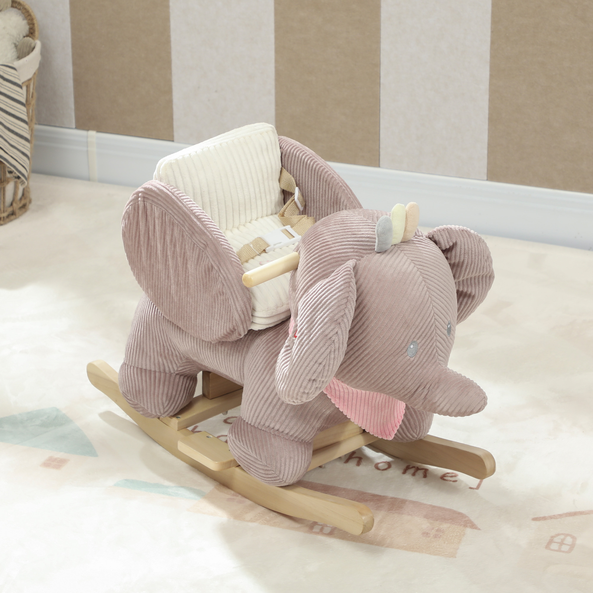 Un juguete balancín de elefante rosa de felpa con asiento blanco y balancines de madera.