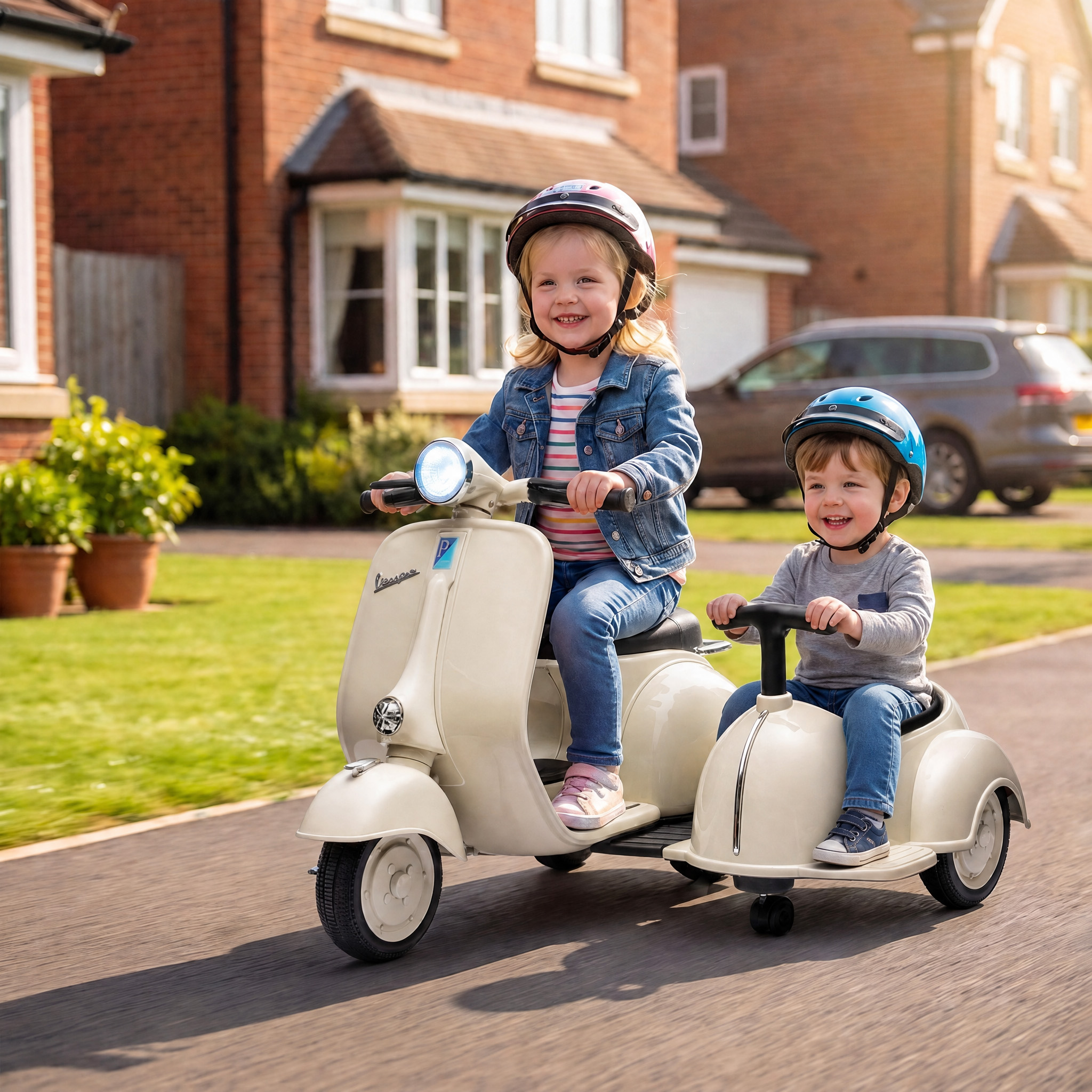 Dos niños pequeños con casco conducen un motopatín de juguete beis con sidecar en una calle residencial.