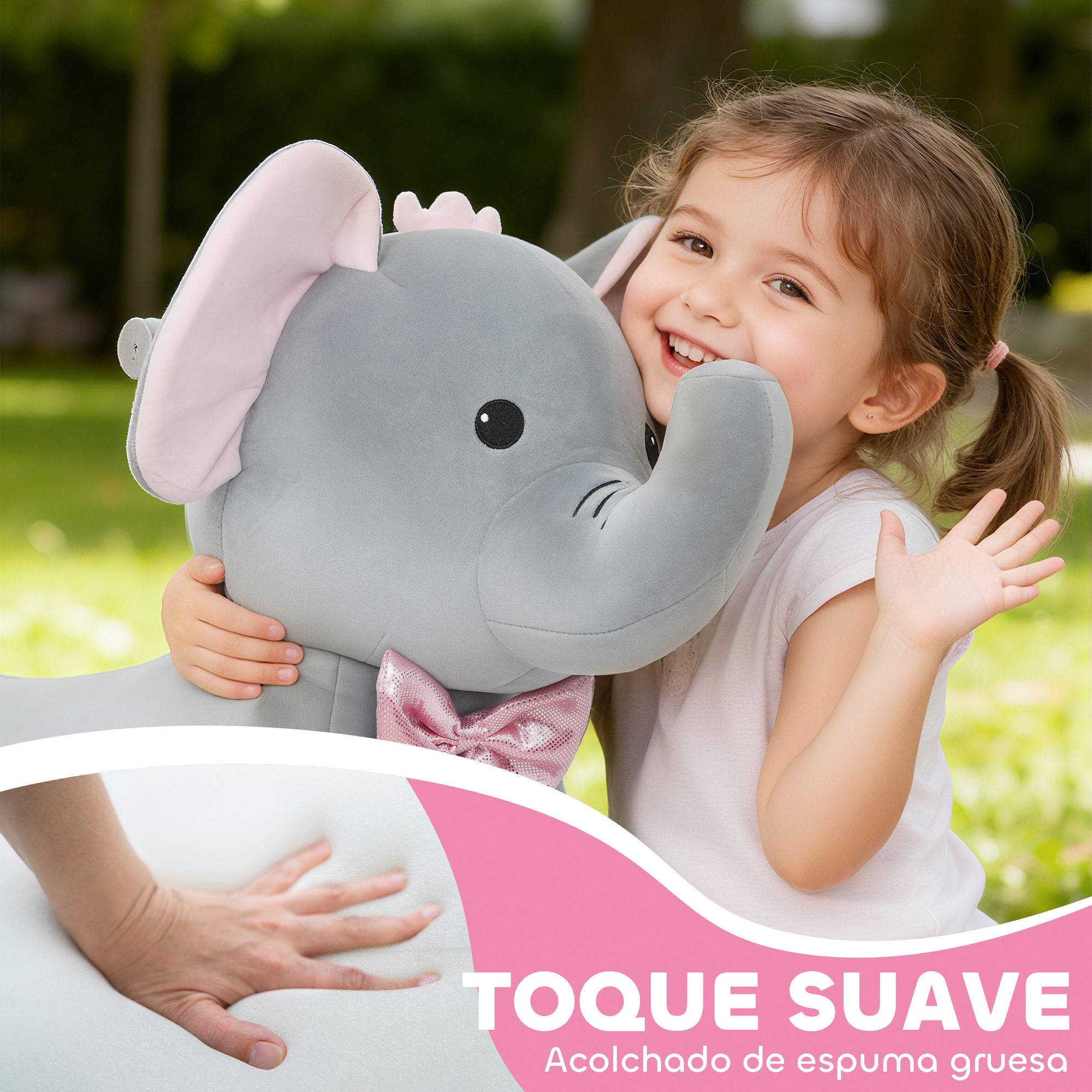 Una niña sonriente abraza un gran elefante de peluche al aire libre, con una mano presionando espuma.