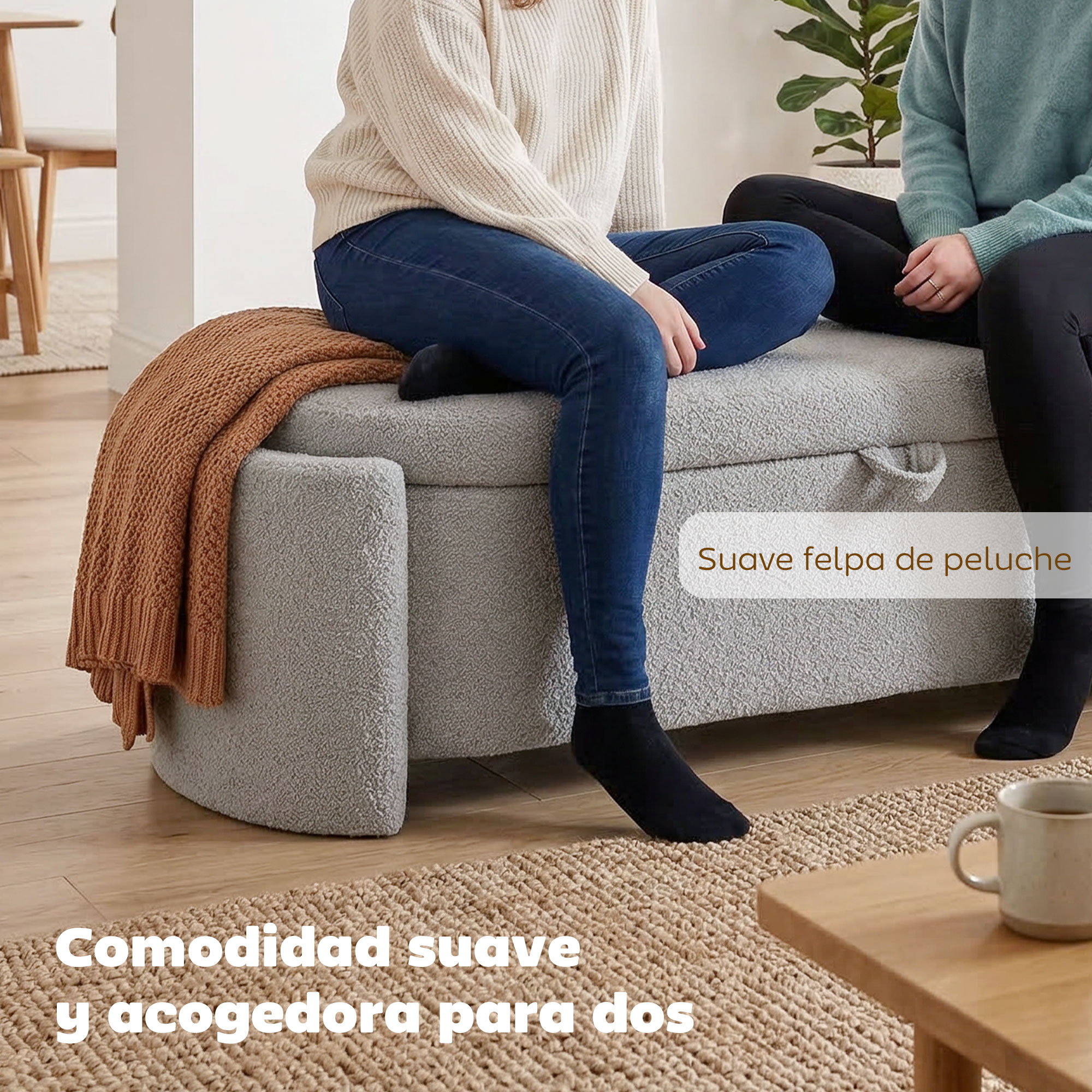 Dos personas se sientan en un banco gris con una manta marrón en una habitación luminosa.