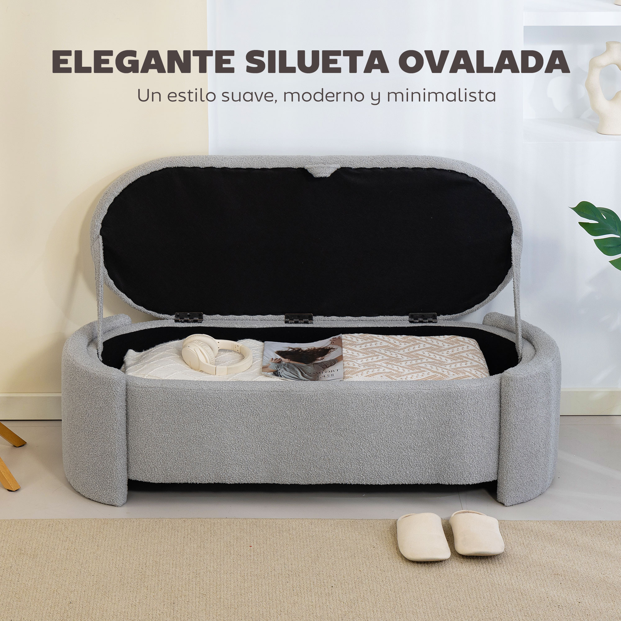 Un banco de almacenamiento tapizado en gris con tapa abierta, con mantas, auriculares y una revista.